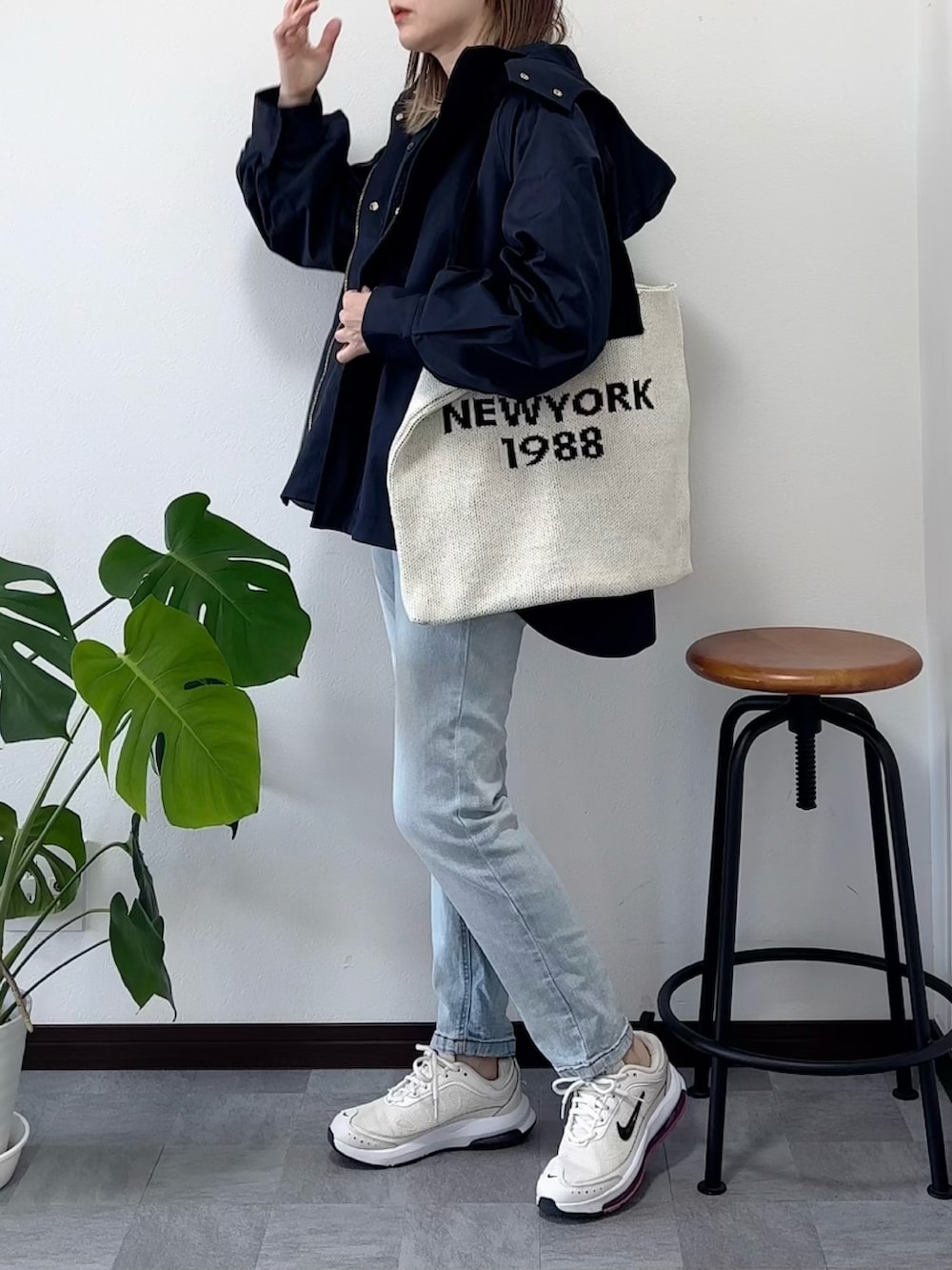 ブルー系のマウンテンパーカー、ブルー系のデニムパンツ、ベージュ系のバッグを着用したレディースの春コーディネートの2枚目の写真