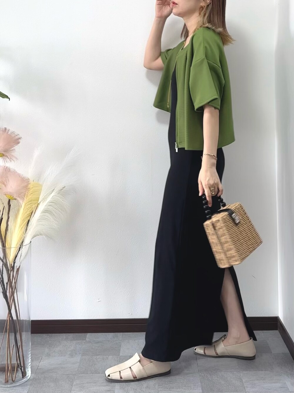 ブラック系のワンピース、グリーン系のカーディガン/ボレロ、ブラウン系のかごバッグを着用したレディースの夏コーディネートの3枚目の写真