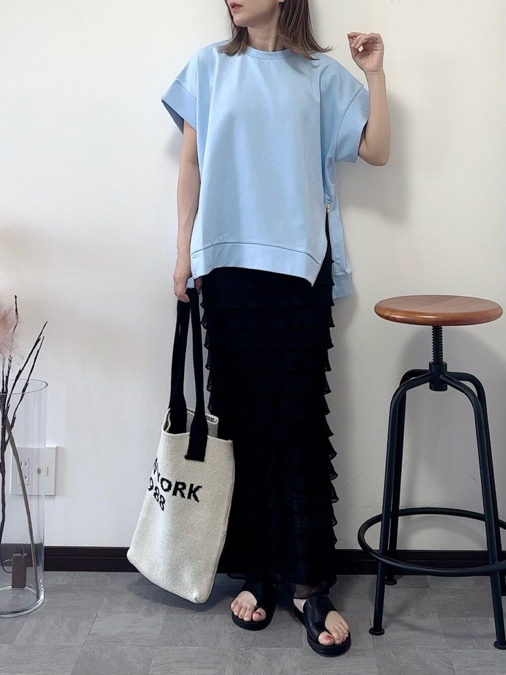 ブルー系のTシャツ/カットソー、ブラック系のスカート、ブラック系のサンダルを着用したレディースの夏コーディネートの2枚目の写真