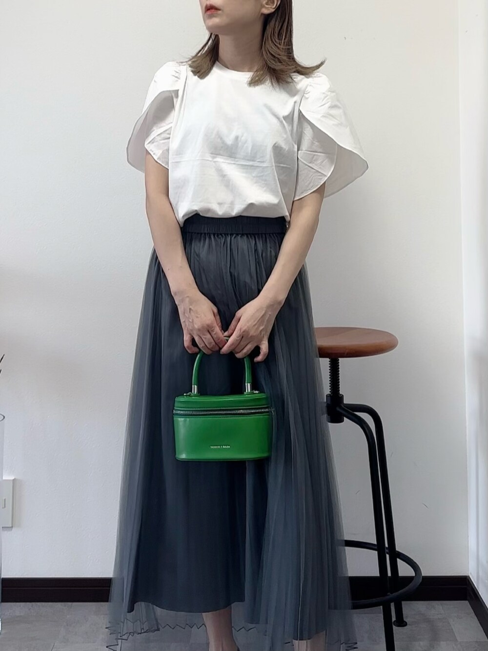 ホワイト系のTシャツ/カットソー、ブラック系のスカートを着用したレディースの夏コーディネートの2枚目の写真