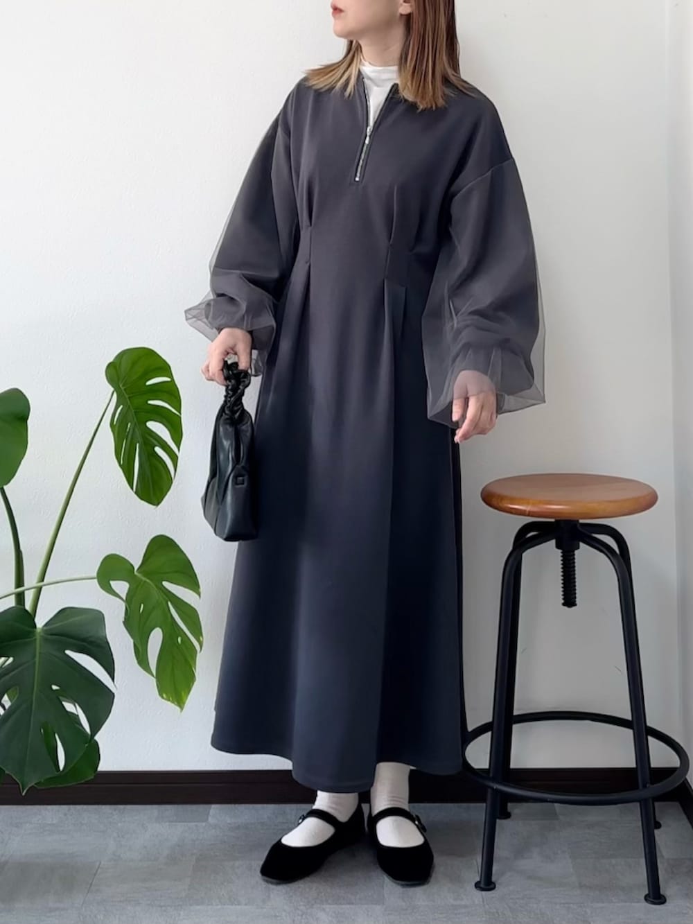 グレー系のワンピース、ブラック系のショルダーバッグ、ブラック系のバレエシューズを着用したレディースの冬コーディネートの2枚目の写真