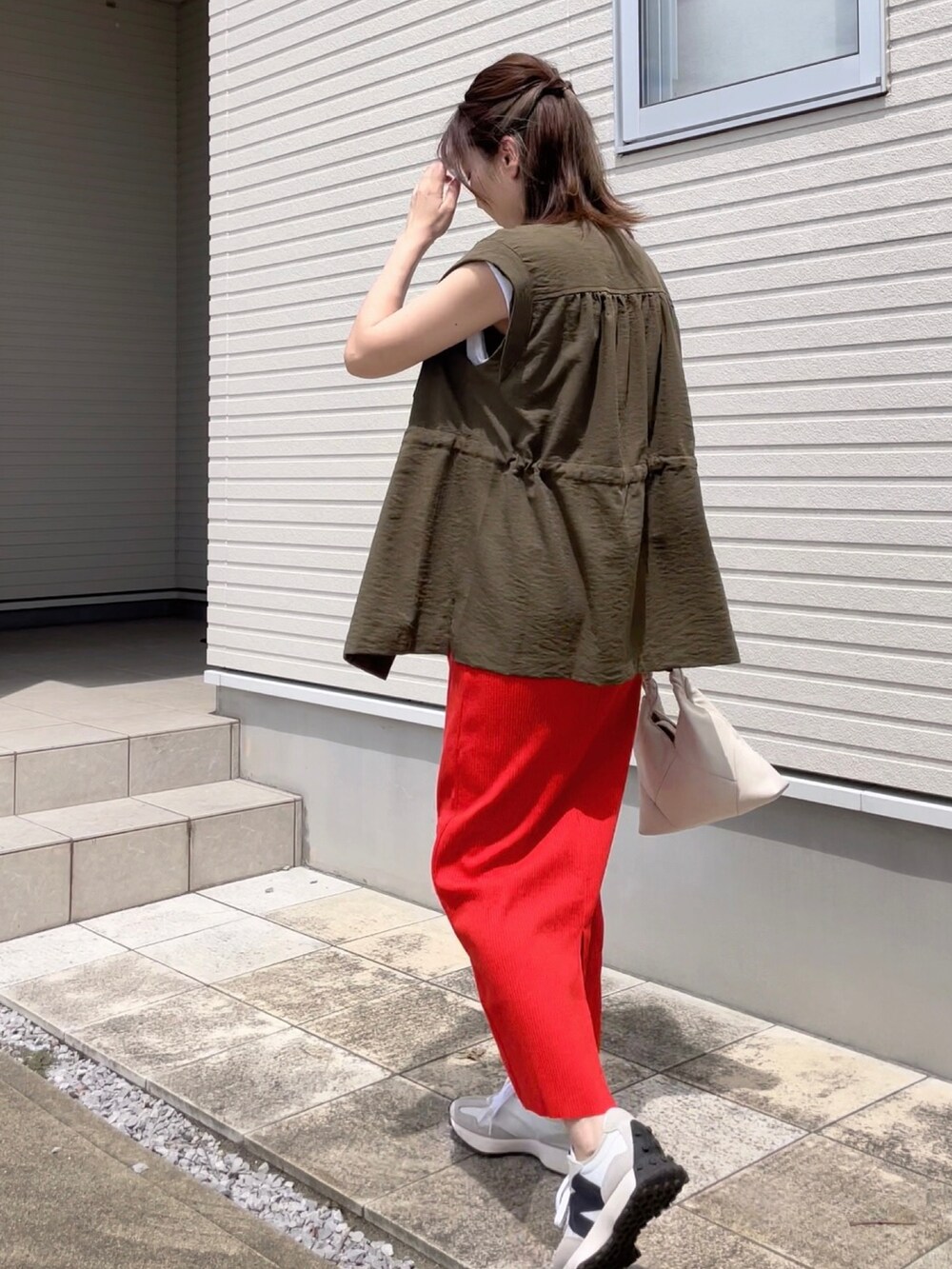 ホワイト系のTシャツ/カットソー、グリーン系のブルゾン、オレンジ系のスカートを着用したレディースの夏コーディネートの2枚目の写真