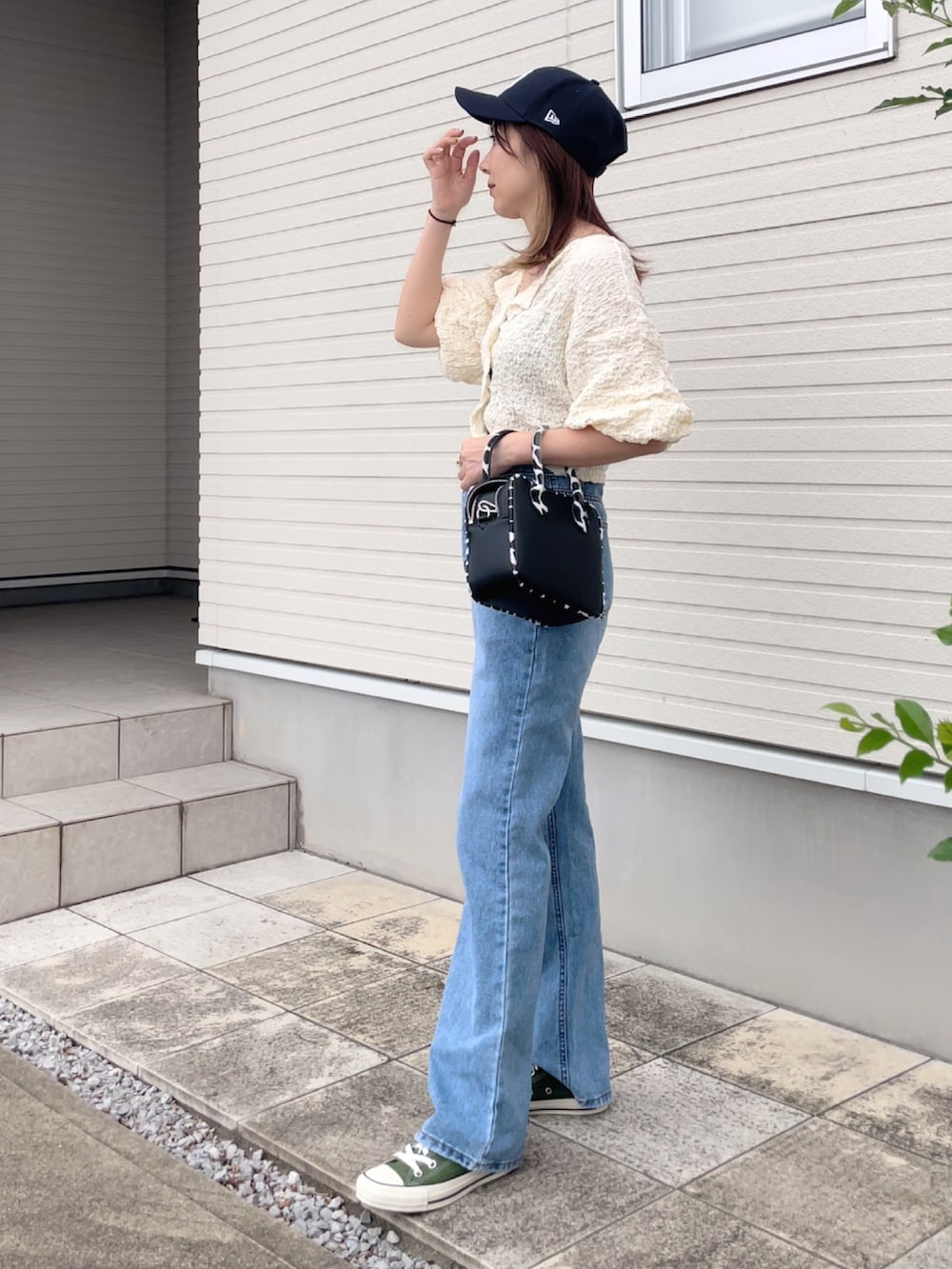 ホワイト系のカーディガン/ボレロ、ブラック系のショルダーバッグ、グリーン系のスニーカーを着用したレディースの秋コーディネートの2枚目の写真