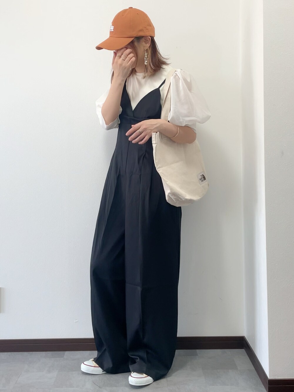 ホワイト系のTシャツ/カットソー、ブラック系のサロペット/オーバーオール、ホワイト系のトートバッグを着用したレディースの春コーディネートの3枚目の写真