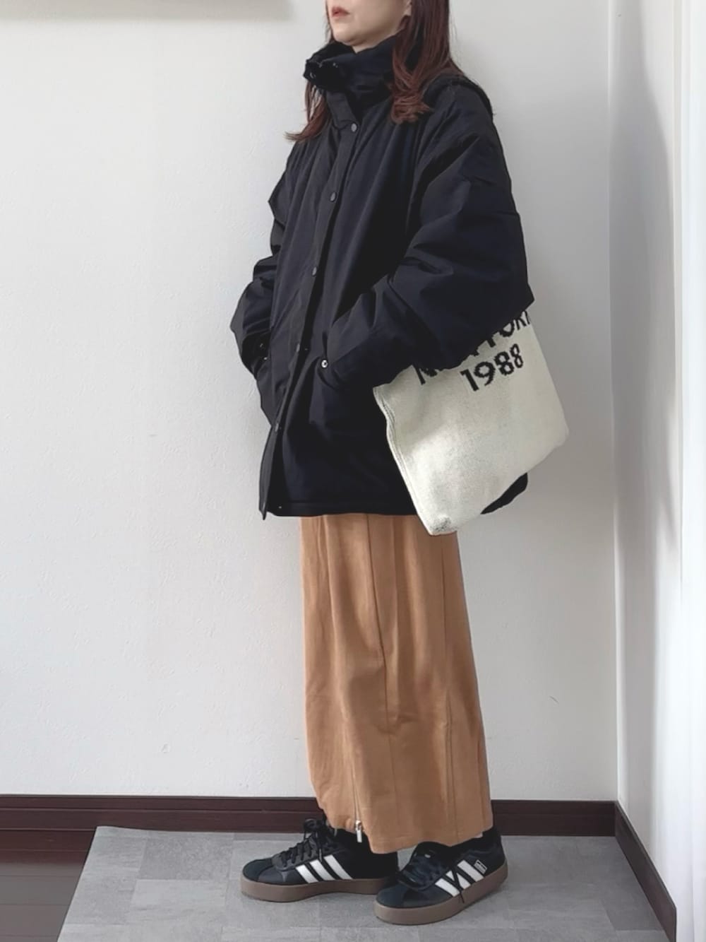 ブラック系のブルゾンを着用したレディースの秋コーディネートの2枚目の写真