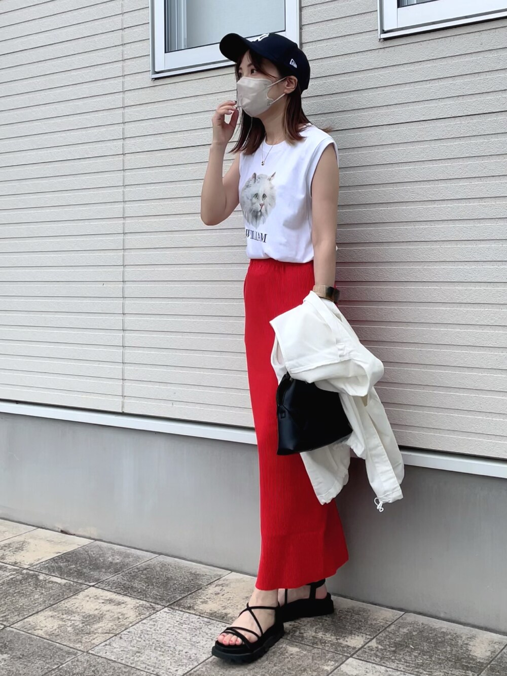 ホワイト系のTシャツ/カットソー、ホワイト系のベスト、オレンジ系のスカートを着用したレディースの夏コーディネートの2枚目の写真