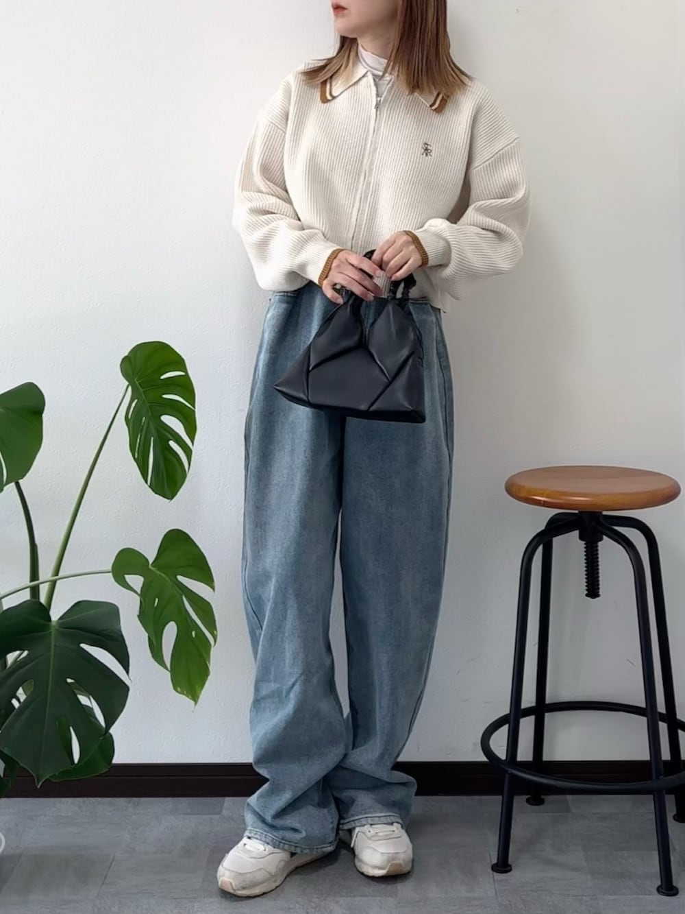 ホワイト系のニット/セーター、ブルー系のデニムパンツ、ホワイト系のスニーカーを着用したレディースの冬コーディネートの2枚目の写真