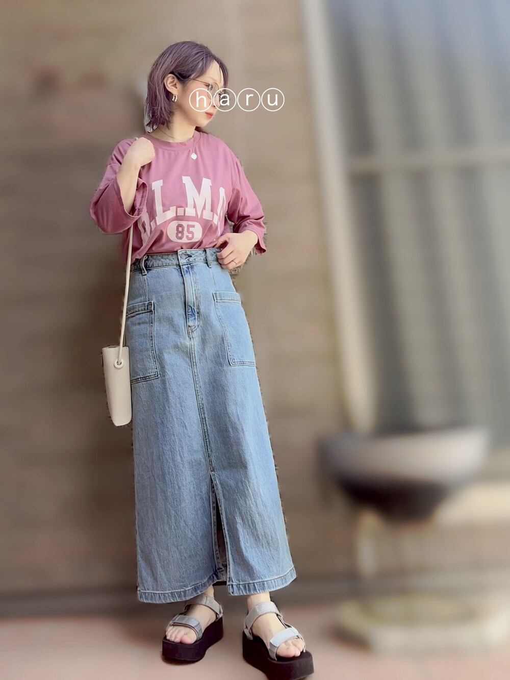 シルバー系のサンダル、ブルー系のデニムスカート、シルバー系のショルダーバッグを着用したレディースの夏コーディネートの2枚目の写真