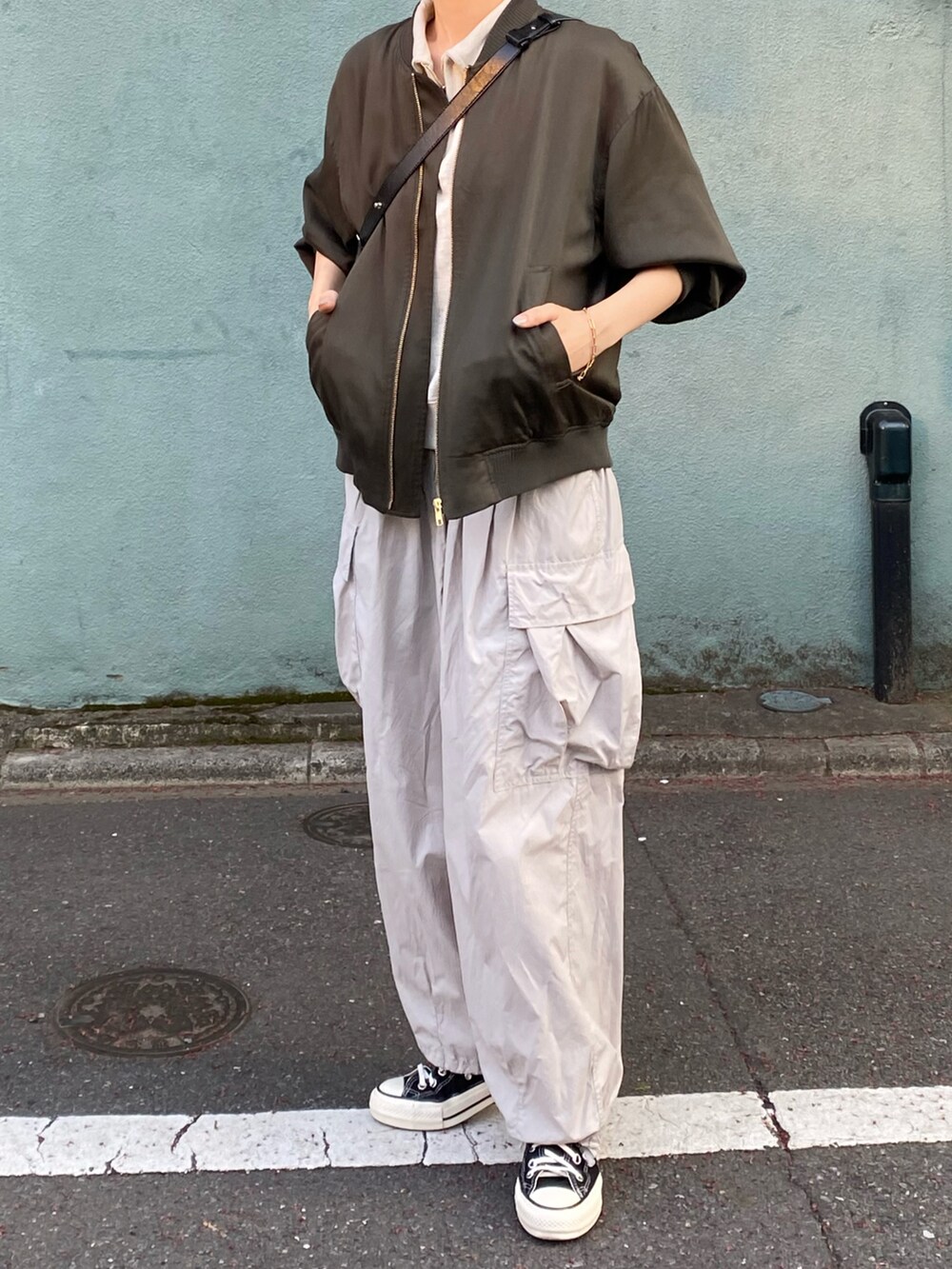 グレー系のカーゴパンツ、ブラック系のスニーカーを着用したレディースの夏コーディネートの2枚目の写真