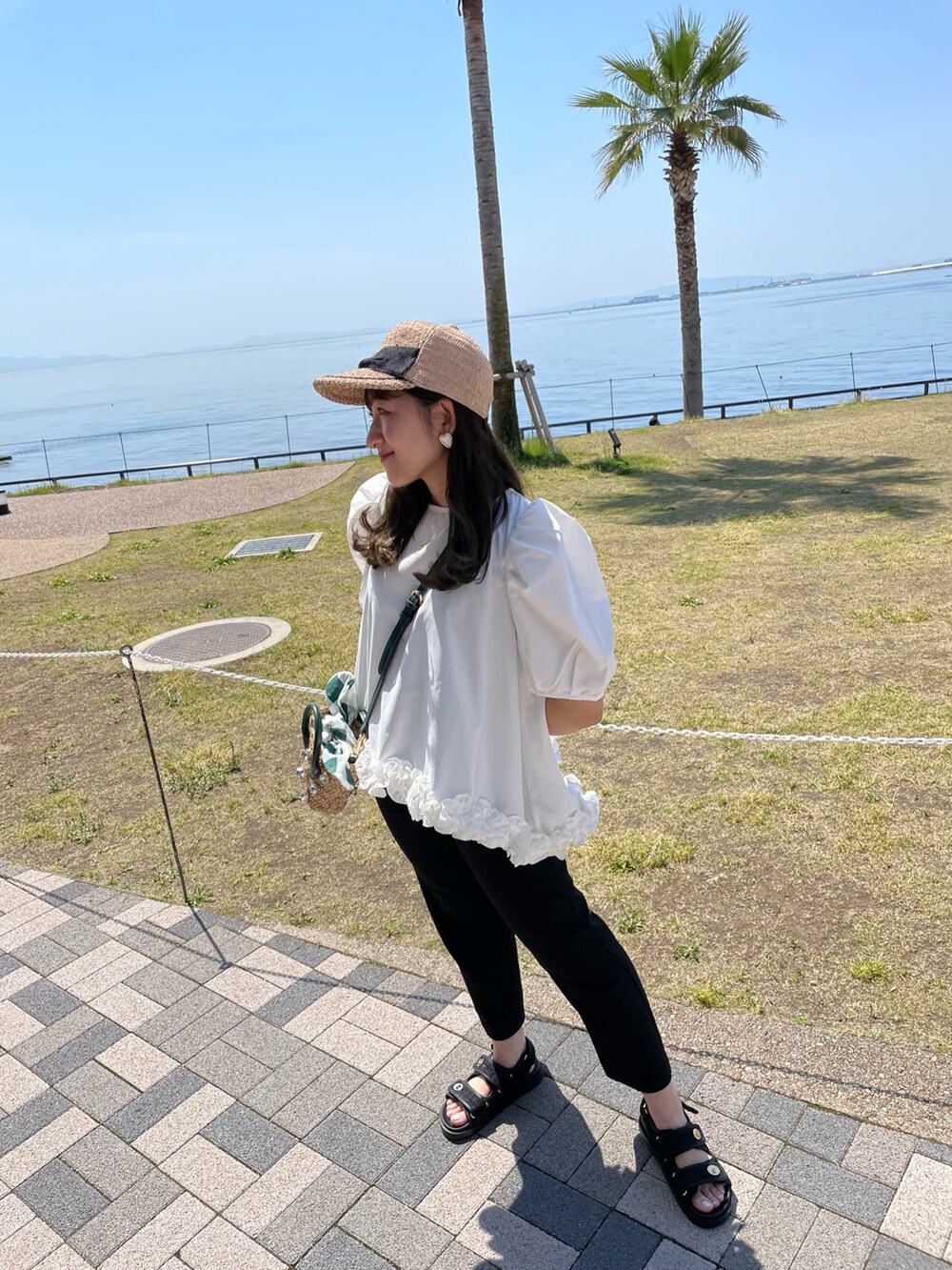 ホワイト系のシャツ/ブラウス、グリーン系のショルダーバッグ、ブラック系のパンツを着用したレディースの夏コーディネートの3枚目の写真