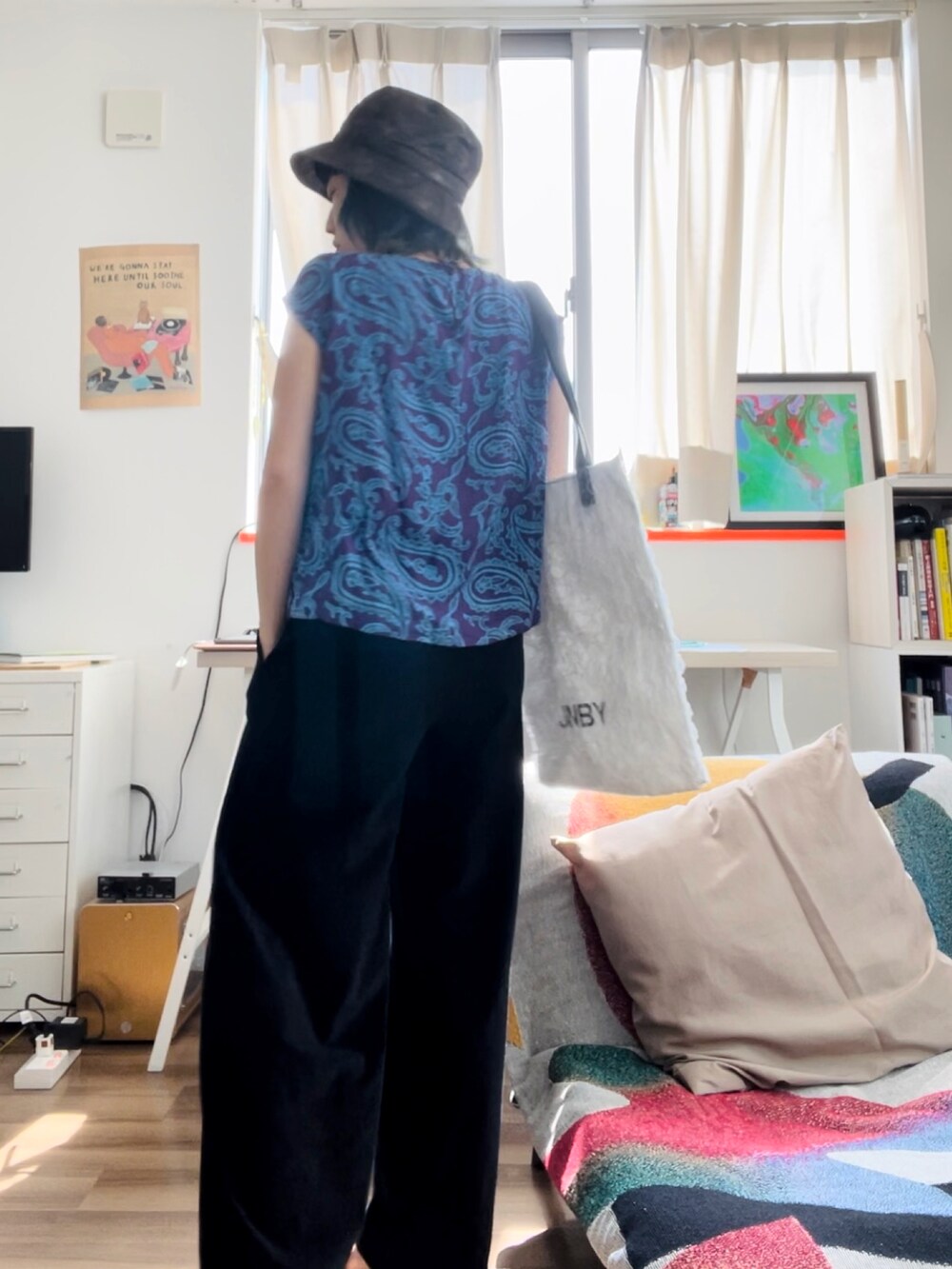 ホワイト系のトートバッグ、ブラック系のその他パンツ、グリーン系のハットを着用したレディースの春コーディネートの2枚目の写真