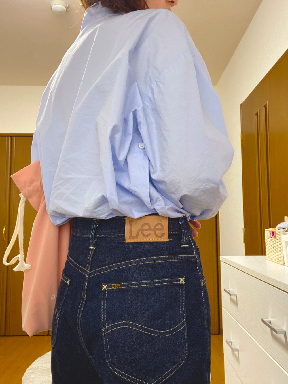 ブルー系のシャツ/ブラウス、ブルー系のデニムパンツ、ピンク系のエコバッグ/サブバッグを着用したレディースの夏コーディネートの2枚目の写真