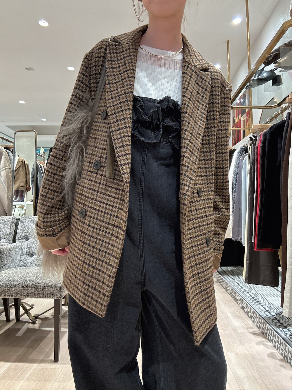 イエロー系のテーラードジャケット、ブラック系のサロペット/オーバーオール、ホワイト系のニット/セーターを着用したレディースの秋コーディネートの2枚目の写真