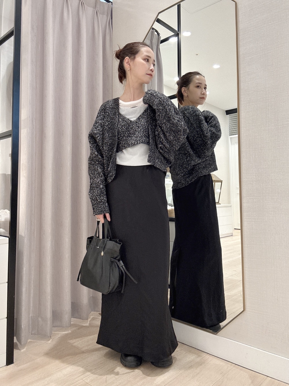 ブラック系のカーディガン/ボレロ、ホワイト系のTシャツ/カットソー、ブラック系のスカートを着用したレディースの秋コーディネートの2枚目の写真