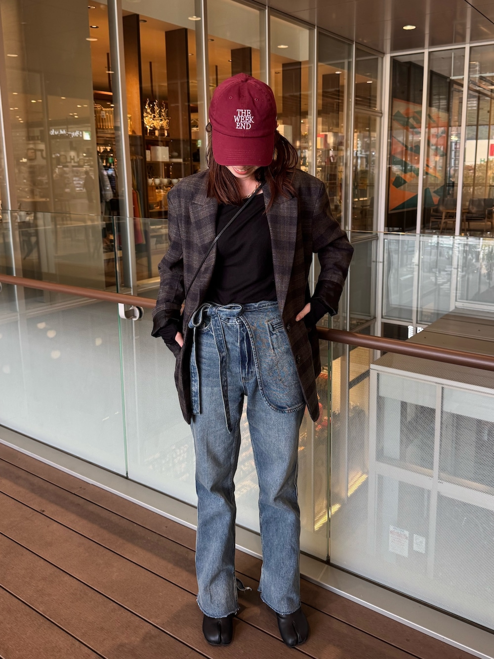 ブルー系のデニムパンツ、ブラック系のTシャツ/カットソーを着用したレディースの秋コーディネートの2枚目の写真