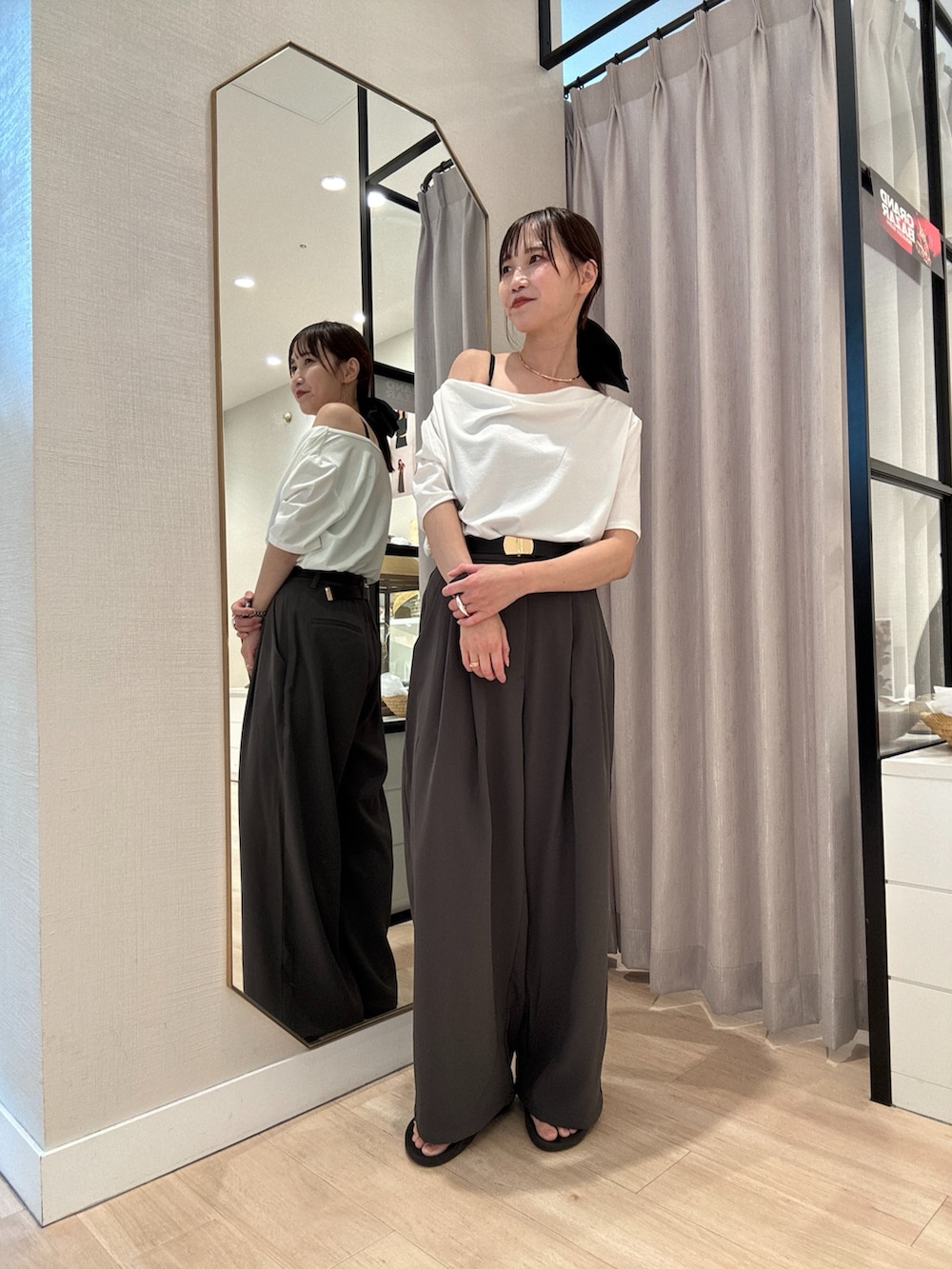 グレー系のスラックス、ホワイト系のTシャツ/カットソー、ブラック系のベルトを着用したレディースの夏コーディネートの2枚目の写真
