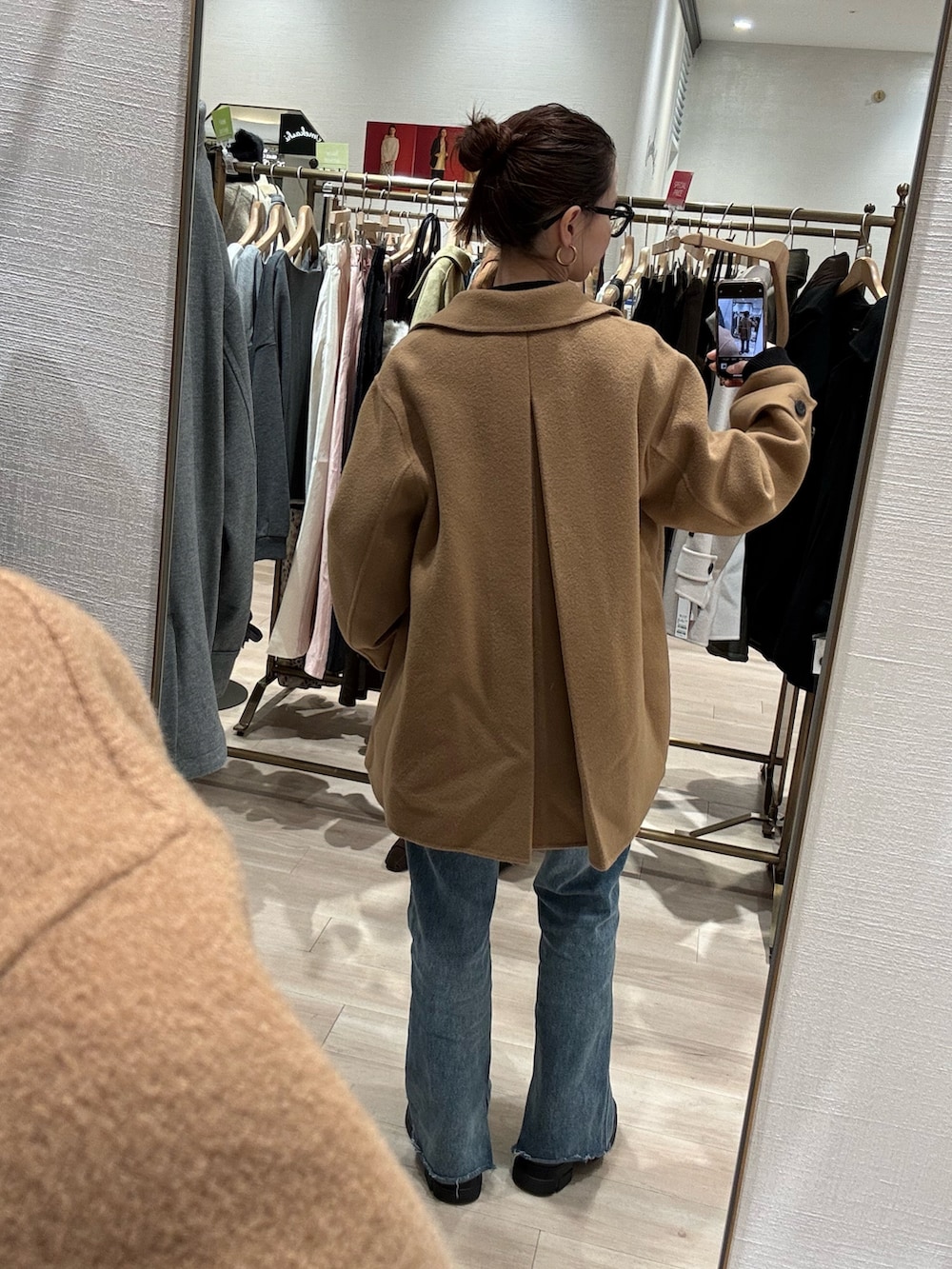 イエロー系のピーコート、ブルー系のデニムパンツを着用したレディースの秋コーディネートの3枚目の写真