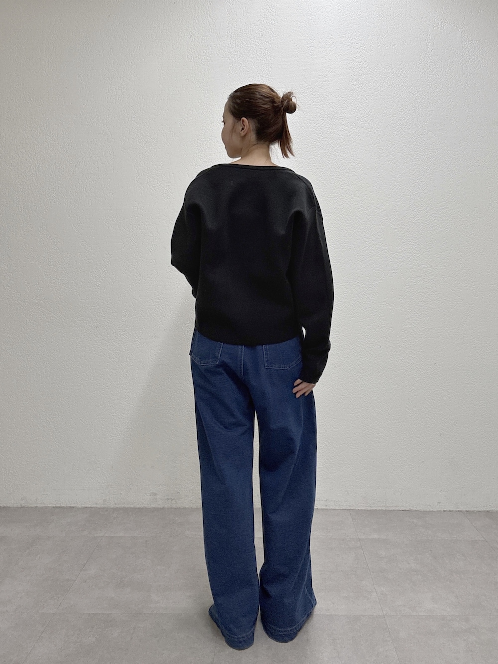 ブルー系のデニムパンツ、ブラック系のカーディガン/ボレロを着用したレディースの秋コーディネートの4枚目の写真