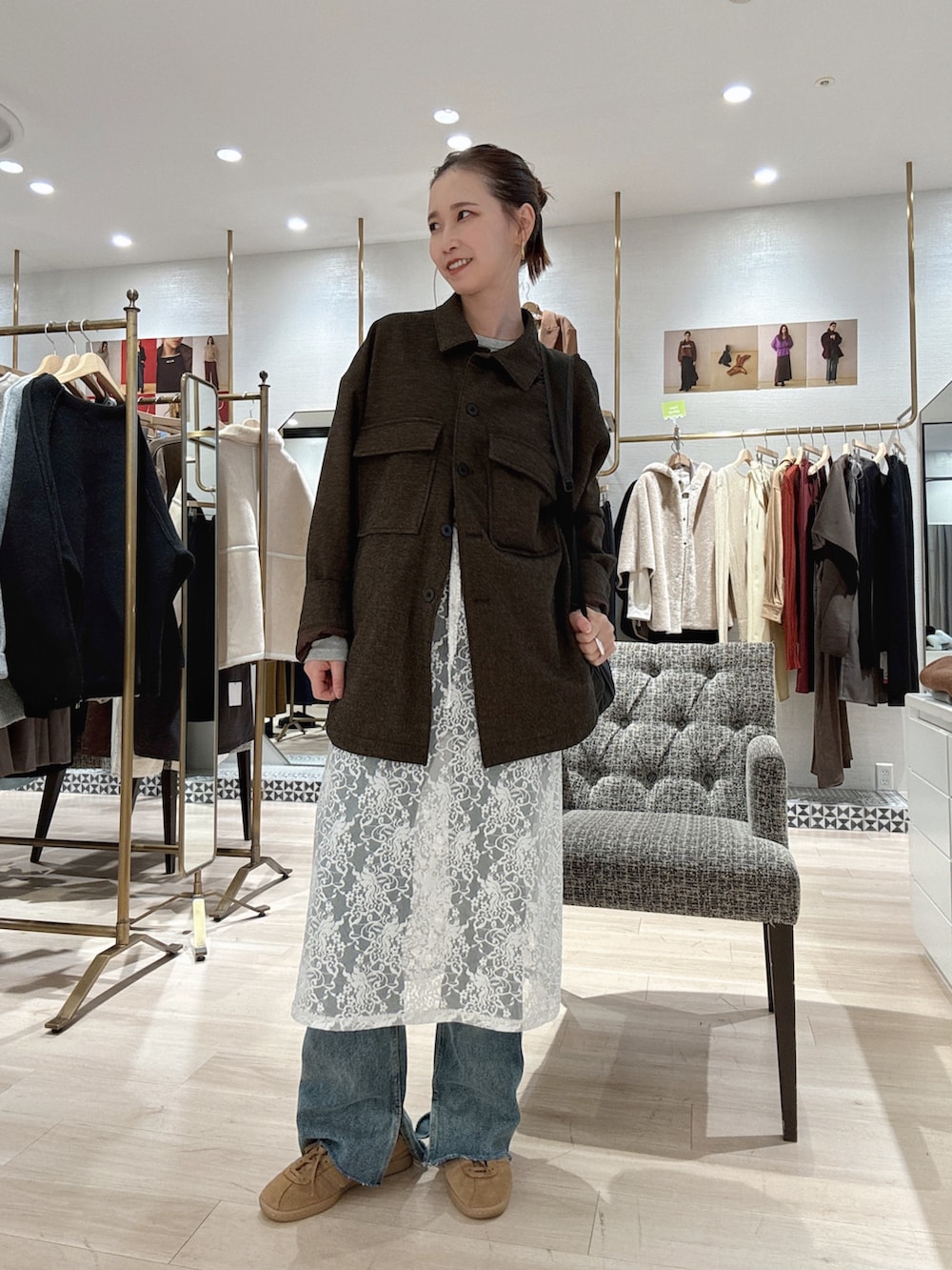 ブラウン系のブルゾン、ホワイト系のスカート、ブルー系のデニムパンツを着用したレディースの秋コーディネートの3枚目の写真