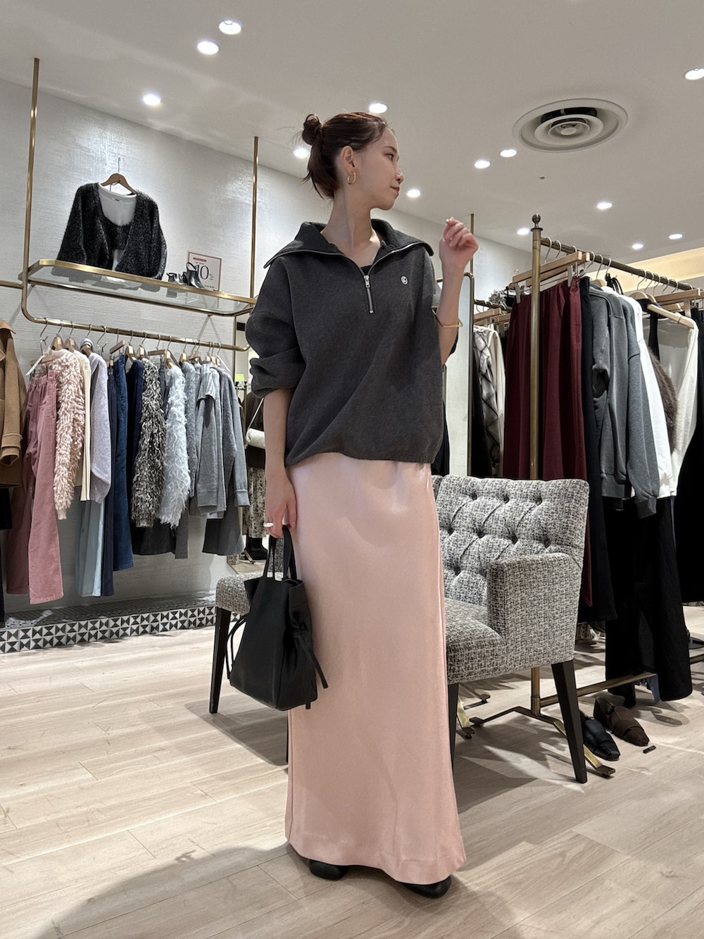 グレー系のスウェット、ピンク系のスカート、ブラック系のショルダーバッグを着用したレディースの秋コーディネートの2枚目の写真
