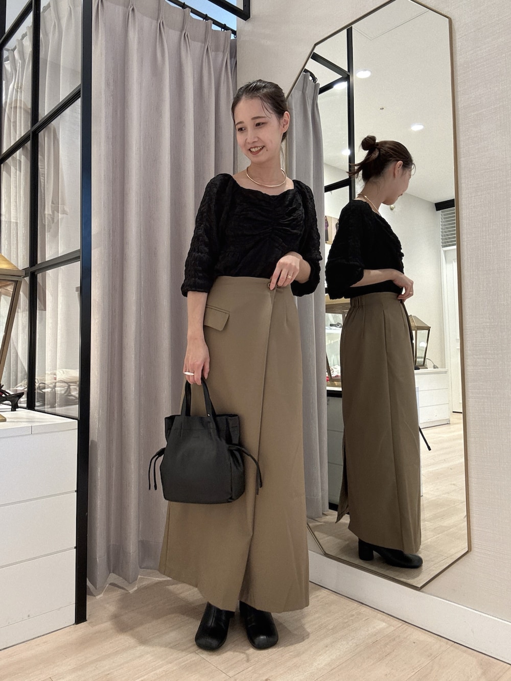 ブラック系のシャツ/ブラウス、ベージュ系のスカート、ブラック系のショルダーバッグを着用したレディースの秋コーディネートの3枚目の写真