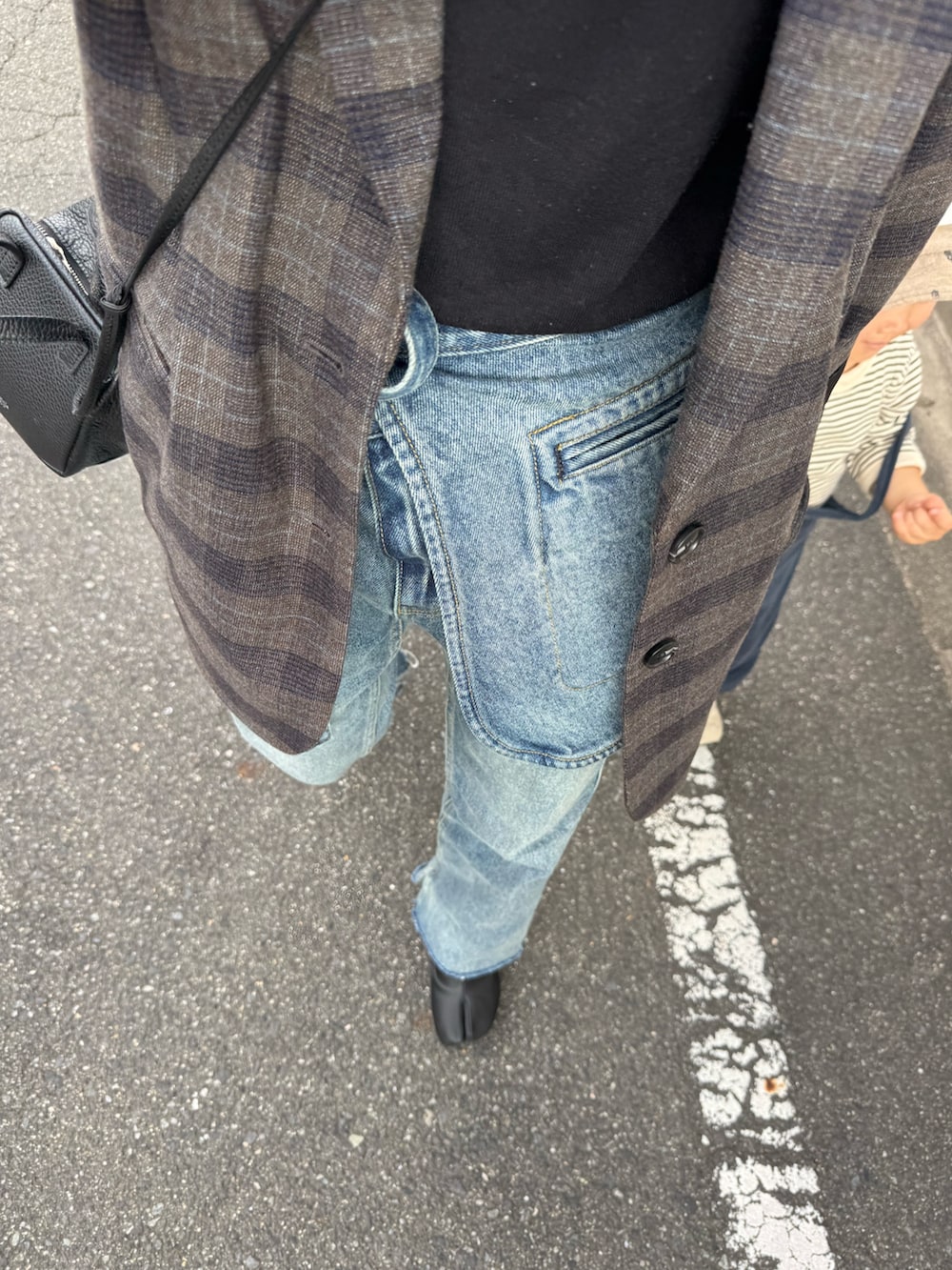 ブルー系のデニムパンツ、ブラック系のTシャツ/カットソーを着用したレディースの秋コーディネートの3枚目の写真