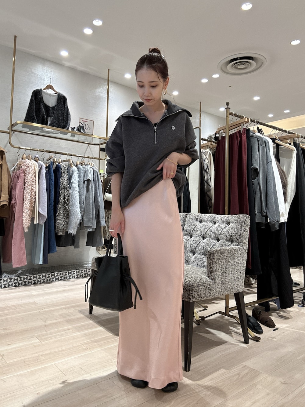 グレー系のスウェット、ピンク系のスカート、ブラック系のショルダーバッグを着用したレディースの秋コーディネートの3枚目の写真