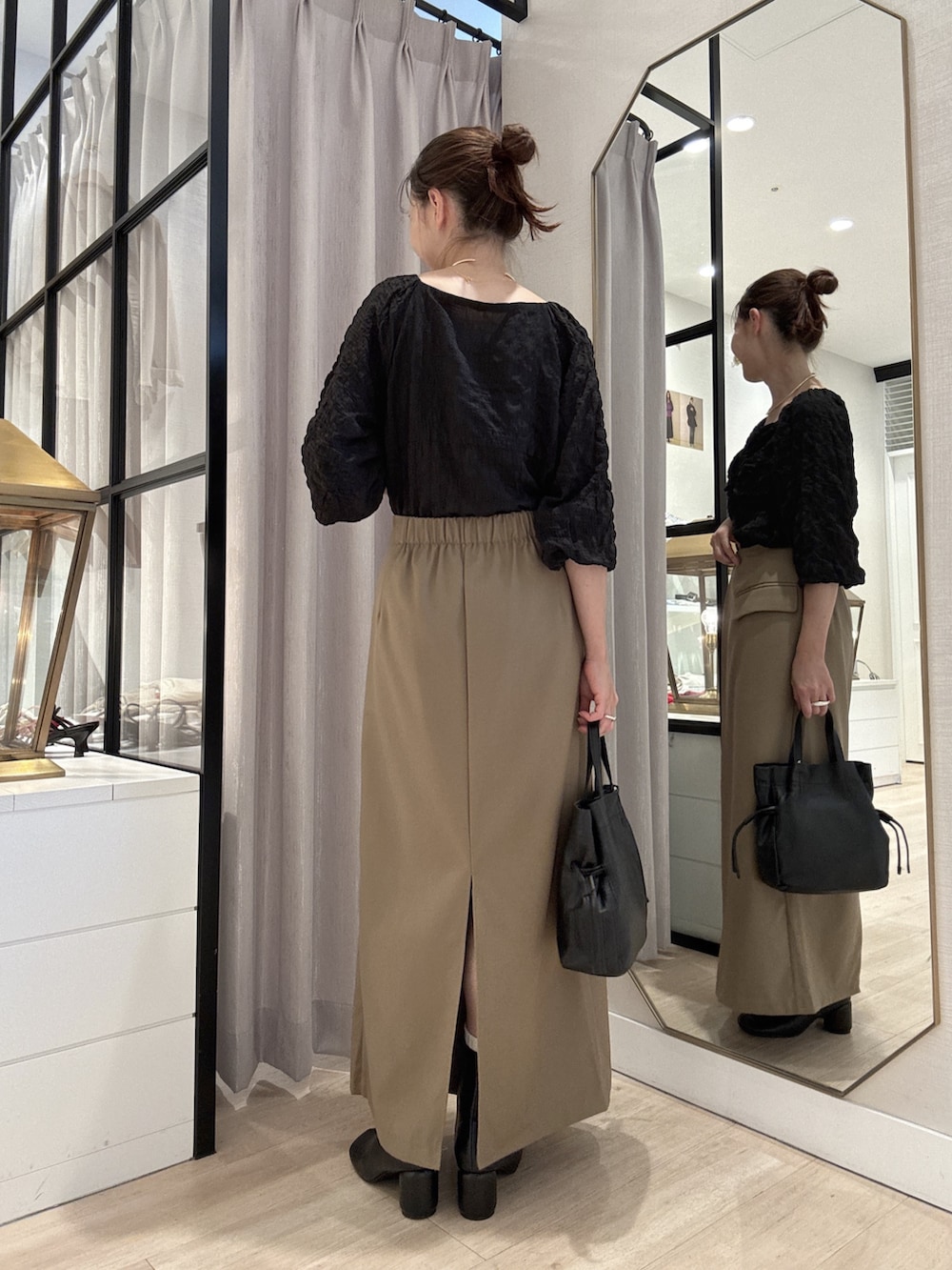 ブラック系のシャツ/ブラウス、ベージュ系のスカート、ブラック系のショルダーバッグを着用したレディースの秋コーディネートの5枚目の写真