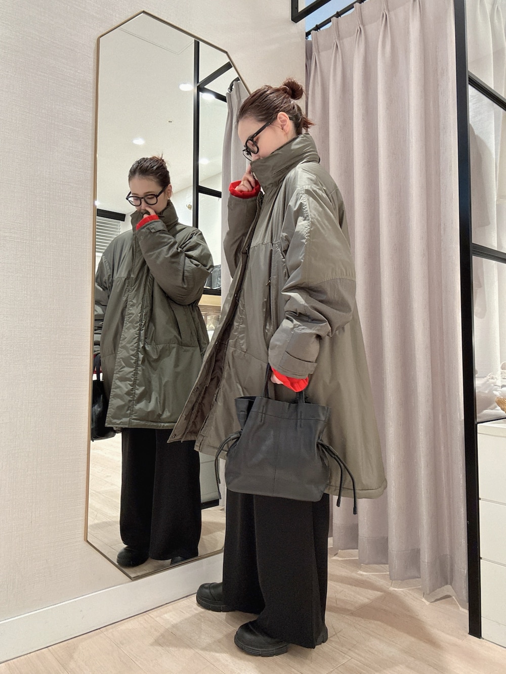 レッド系のカーディガン/ボレロ、グリーン系のその他アウター、ブラック系のその他パンツを着用したレディースの秋コーディネートの3枚目の写真