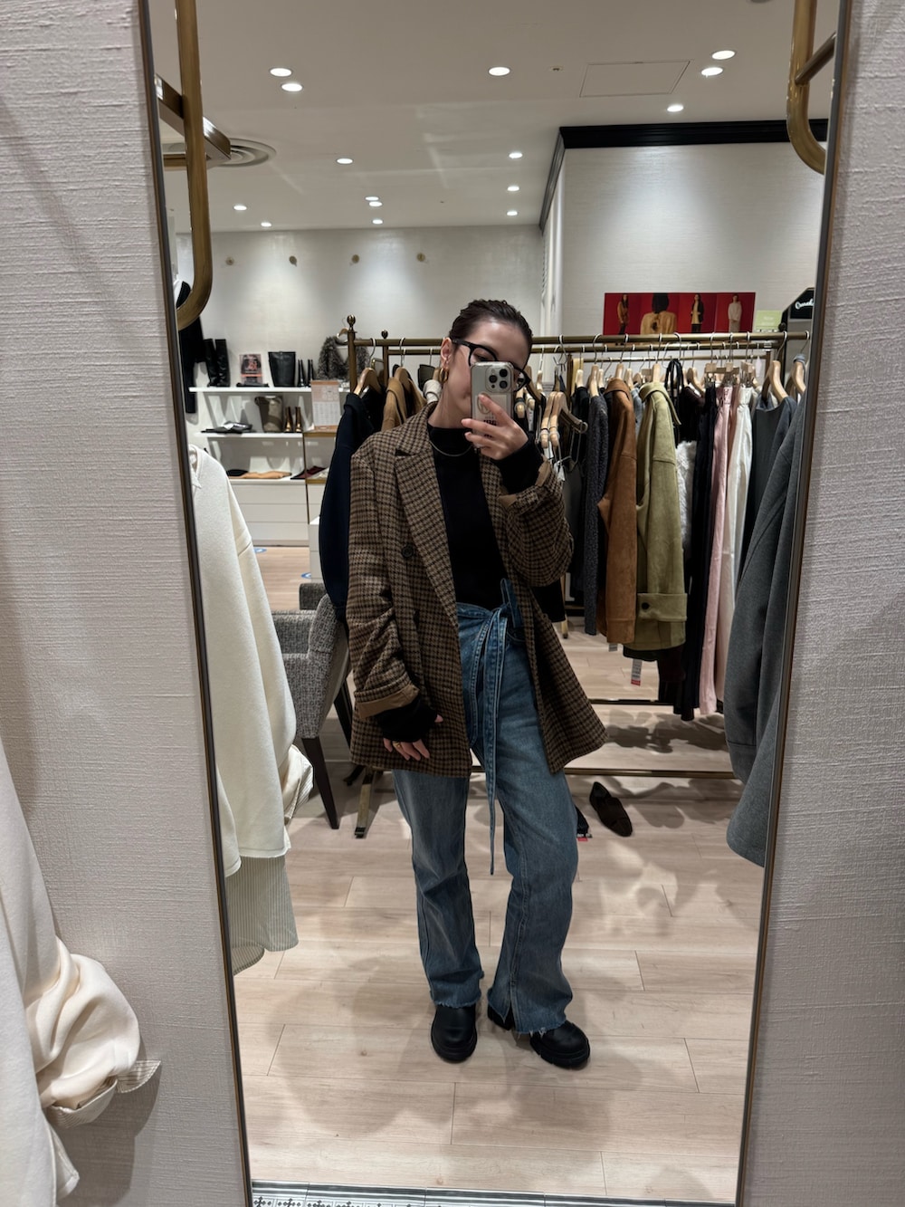 イエロー系のテーラードジャケット、ブルー系のデニムパンツを着用したレディースの秋コーディネートの2枚目の写真