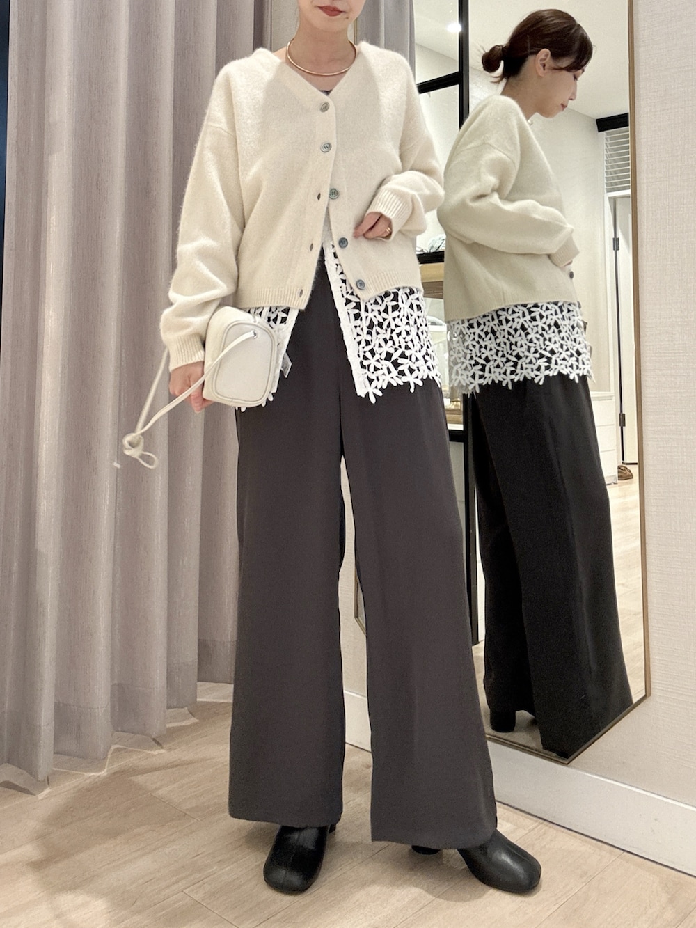 ホワイト系のカーディガン/ボレロ、ホワイト系のキャミソール、グレー系のその他パンツを着用したレディースの秋コーディネートの2枚目の写真