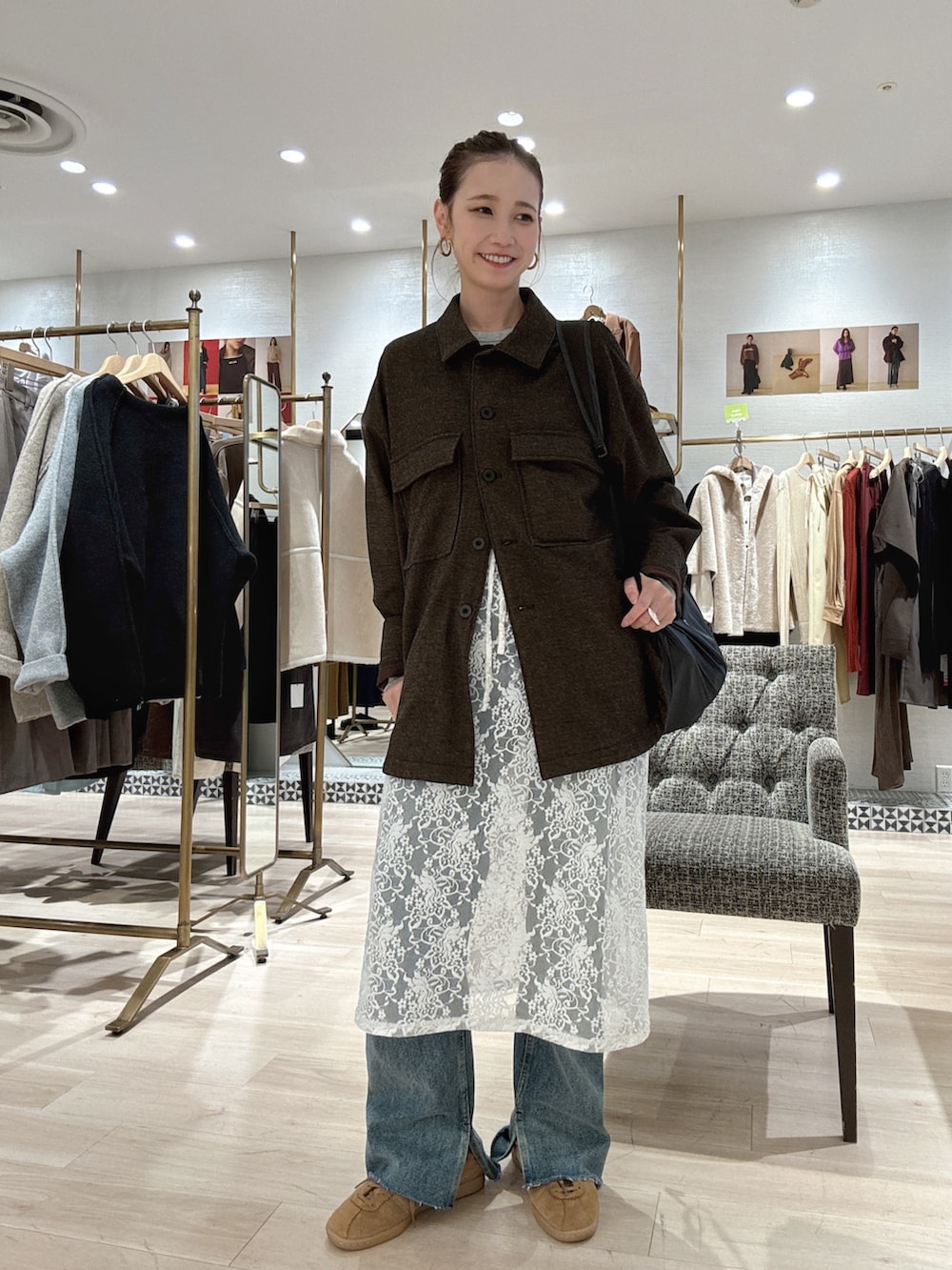 ブラウン系のブルゾン、ホワイト系のスカート、ブルー系のデニムパンツを着用したレディースの秋コーディネートの2枚目の写真