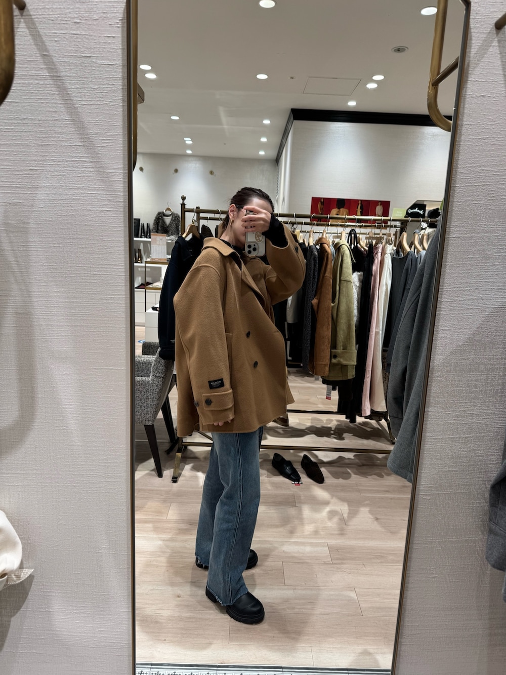 イエロー系のピーコート、ブルー系のデニムパンツを着用したレディースの秋コーディネートの2枚目の写真