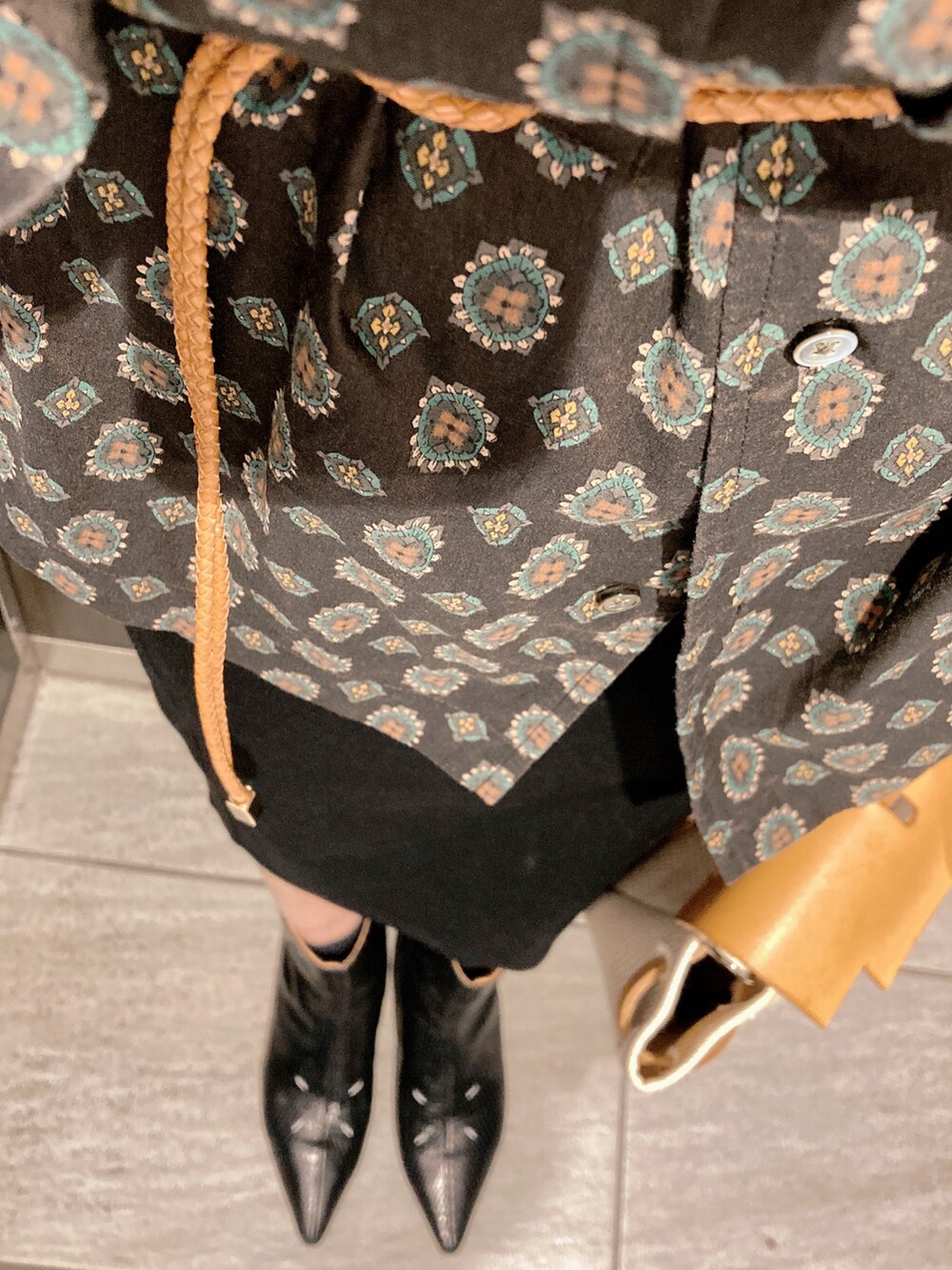 ブラック系のシャツ/ブラウス、ブラック系のブーツ、ベージュ系のバッグを着用したレディースの秋コーディネートの3枚目の写真