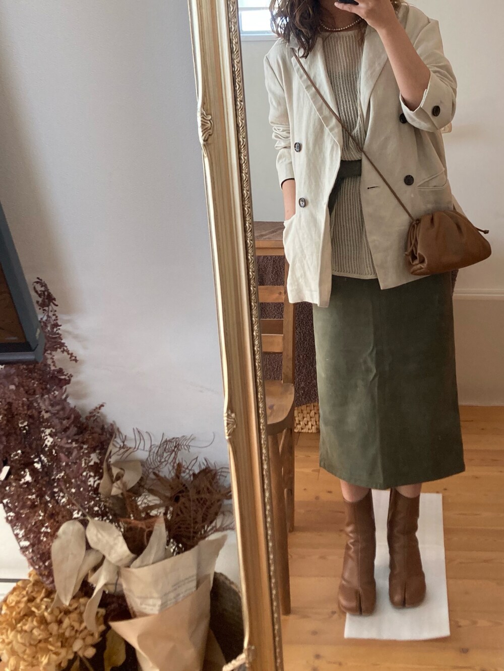 ベージュ系のトップス、グリーン系のスカート、ベージュ系のショルダーバッグを着用したレディースの秋コーディネートの2枚目の写真
