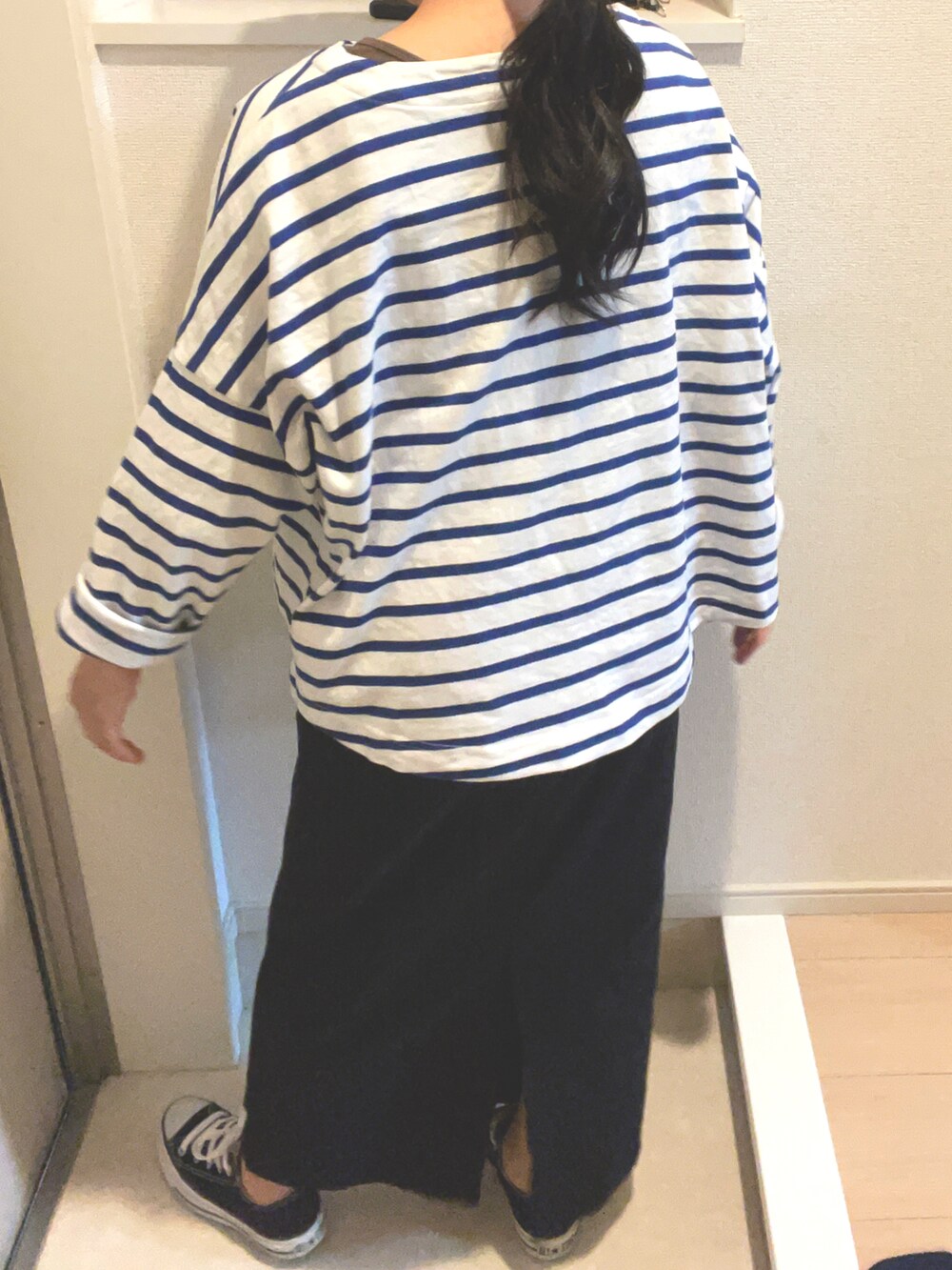 ブラック系のスニーカーを着用したレディースの春コーディネートの2枚目の写真