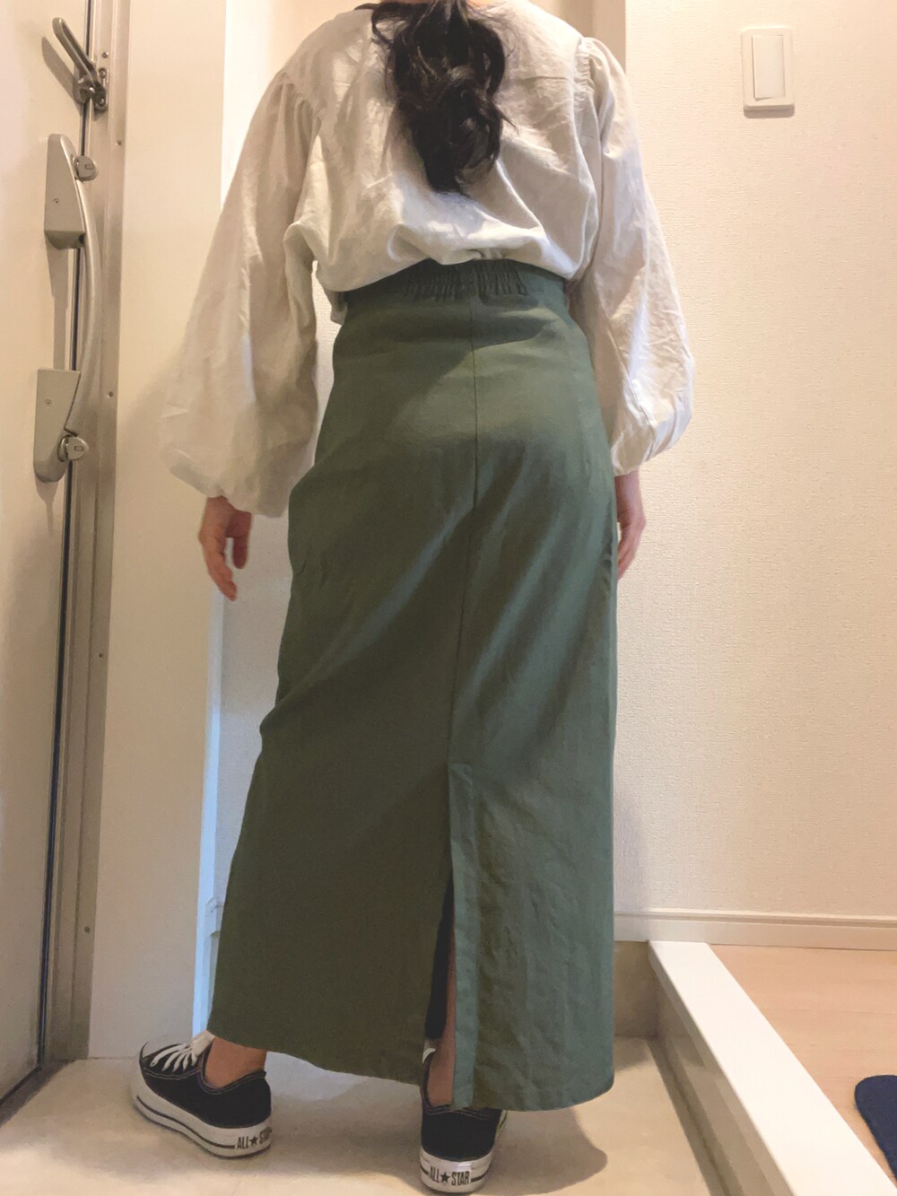 ブラック系のスニーカーを着用したレディースの春コーディネートの2枚目の写真