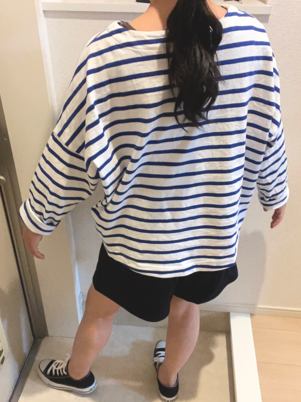 ブラック系のスニーカーを着用したレディースの春コーディネートの2枚目の写真