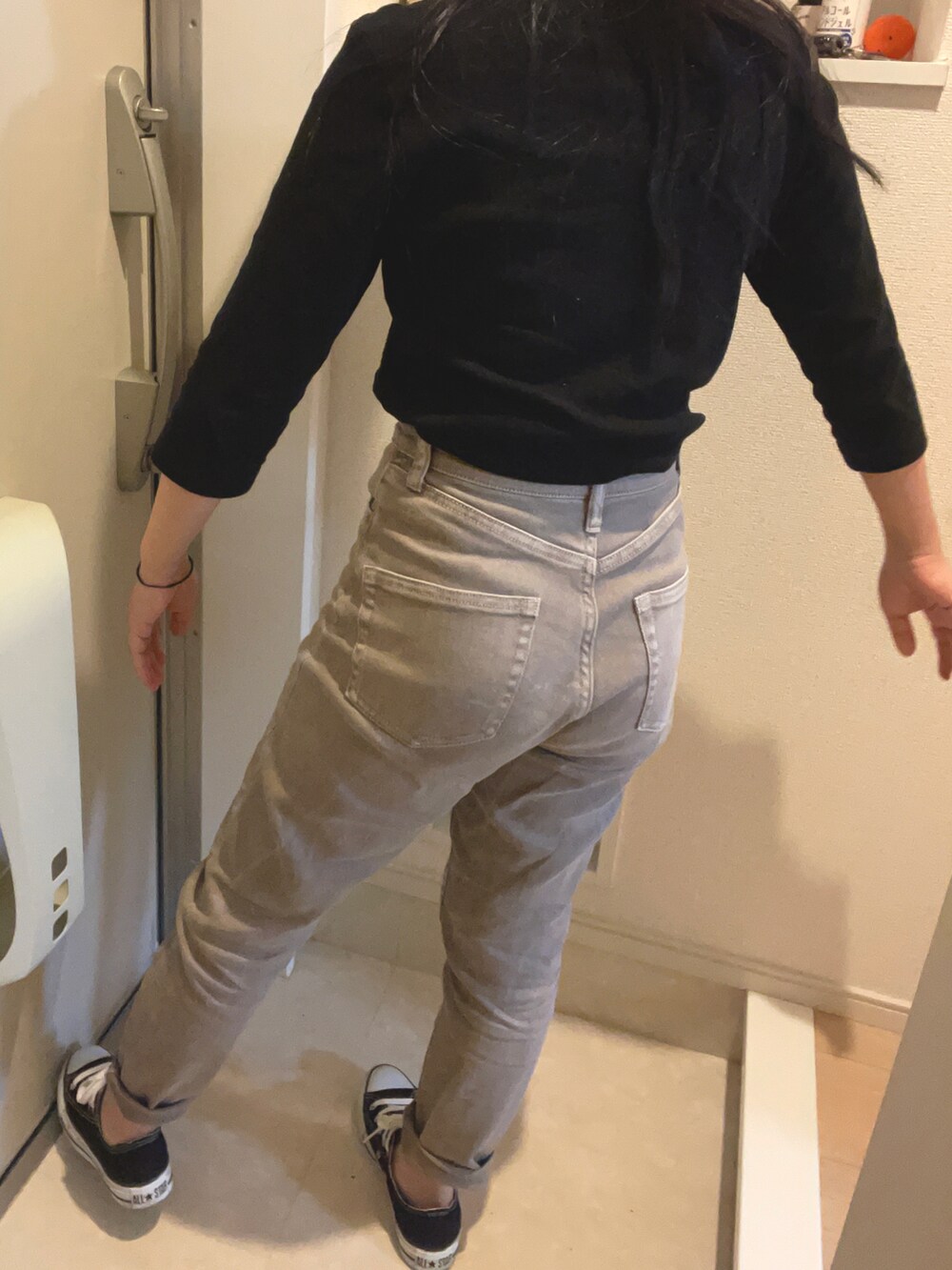 ブラック系のスニーカー、グレー系のパンツを着用したレディースの春コーディネートの2枚目の写真