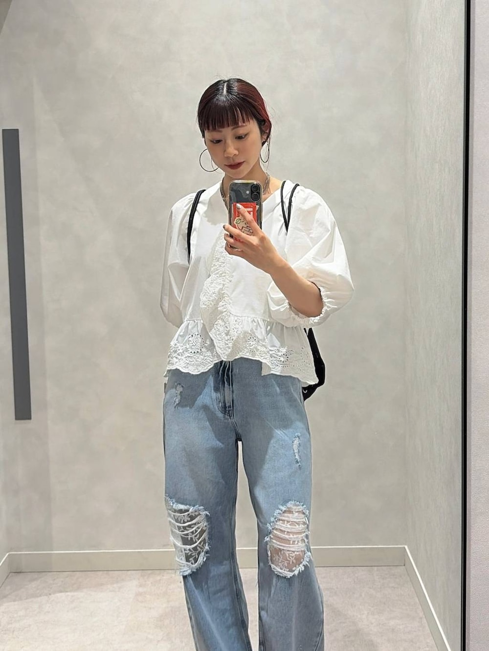 ゴールド系のタンクトップ、ブルー系のデニムパンツ、ホワイト系のシャツ/ブラウスを着用したレディースの春コーディネートの2枚目の写真