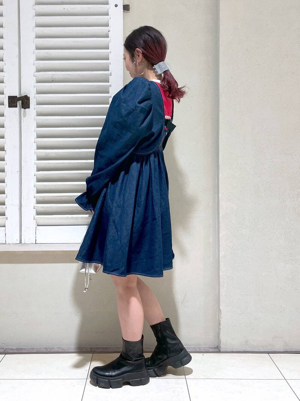 レッド系のTシャツ/カットソー、ブラック系のブーツ、ブラック系のショルダーバッグを着用したレディースの春コーディネートの4枚目の写真