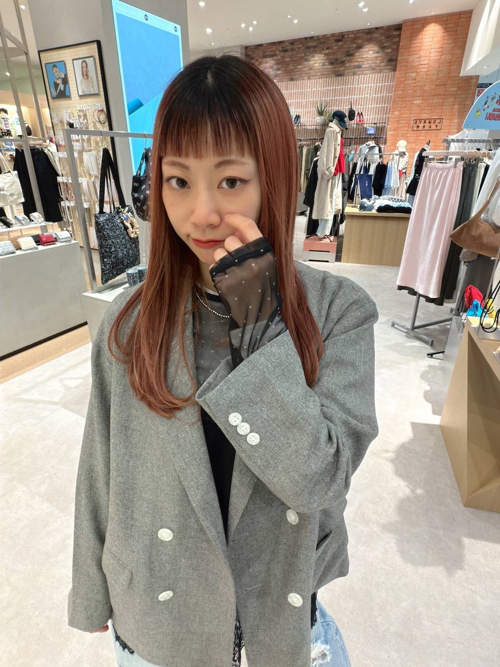 グレー系のテーラードジャケット、ブラック系のTシャツ/カットソー、ブルー系のデニムパンツを着用したレディースの春コーディネートの9枚目の写真