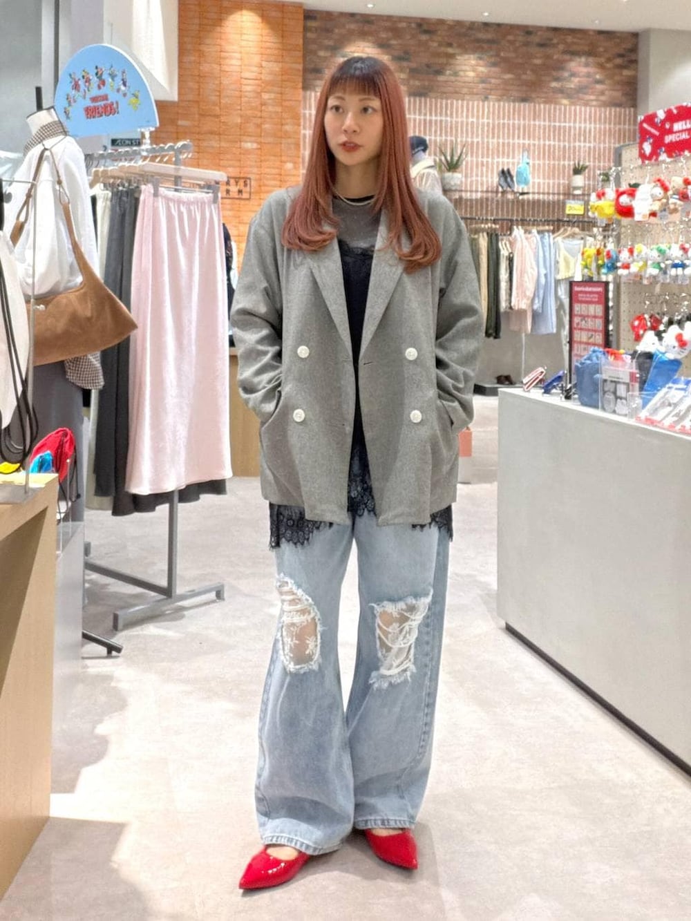 グレー系のテーラードジャケット、ブラック系のTシャツ/カットソー、ブルー系のデニムパンツを着用したレディースの春コーディネートの2枚目の写真