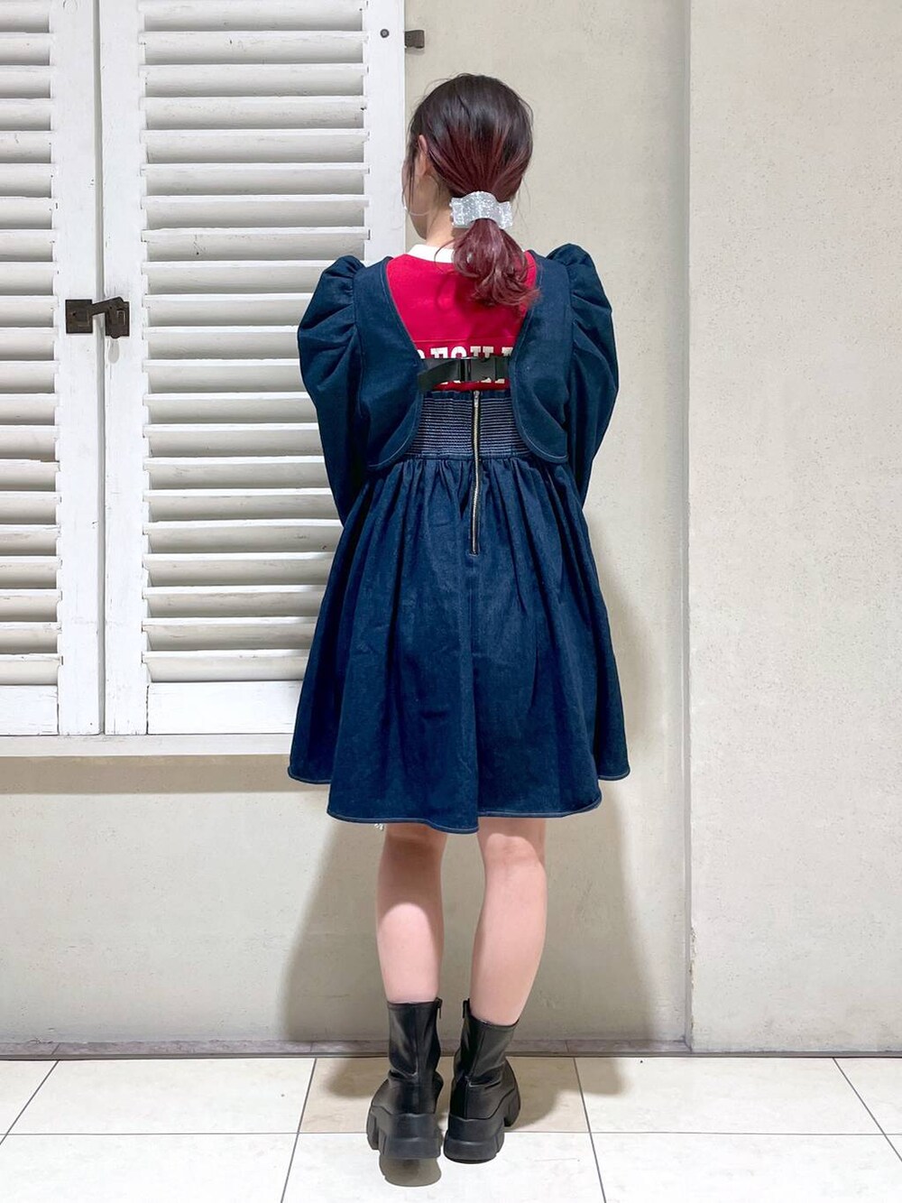 レッド系のTシャツ/カットソー、ブラック系のブーツ、ブラック系のショルダーバッグを着用したレディースの春コーディネートの5枚目の写真