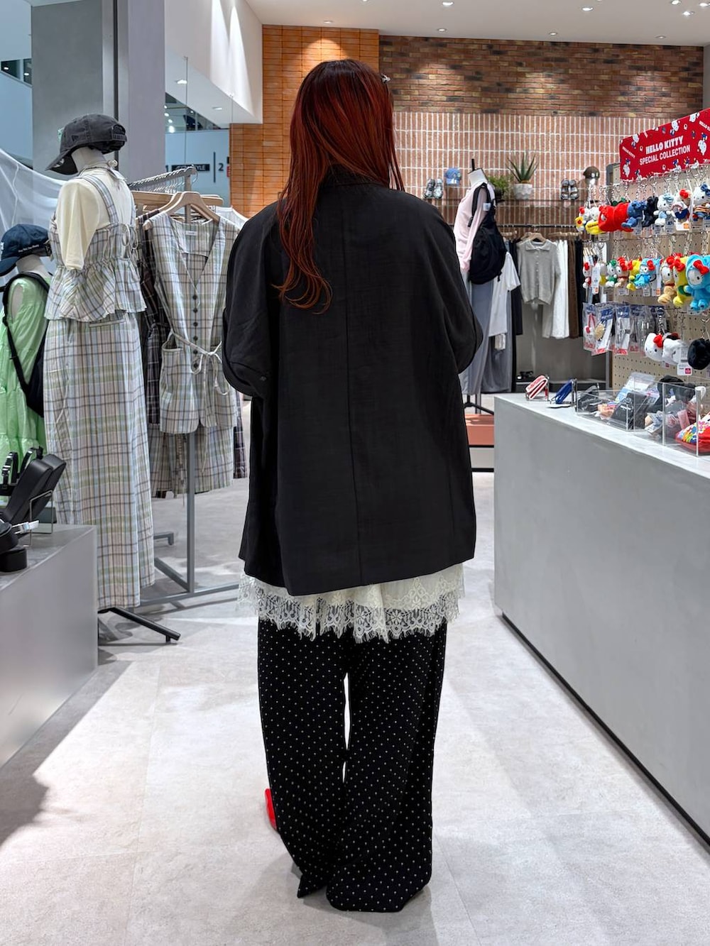 レッド系のパンプス、グレー系のテーラードジャケット、レッド系のタンクトップを着用したレディースの春コーディネートの5枚目の写真