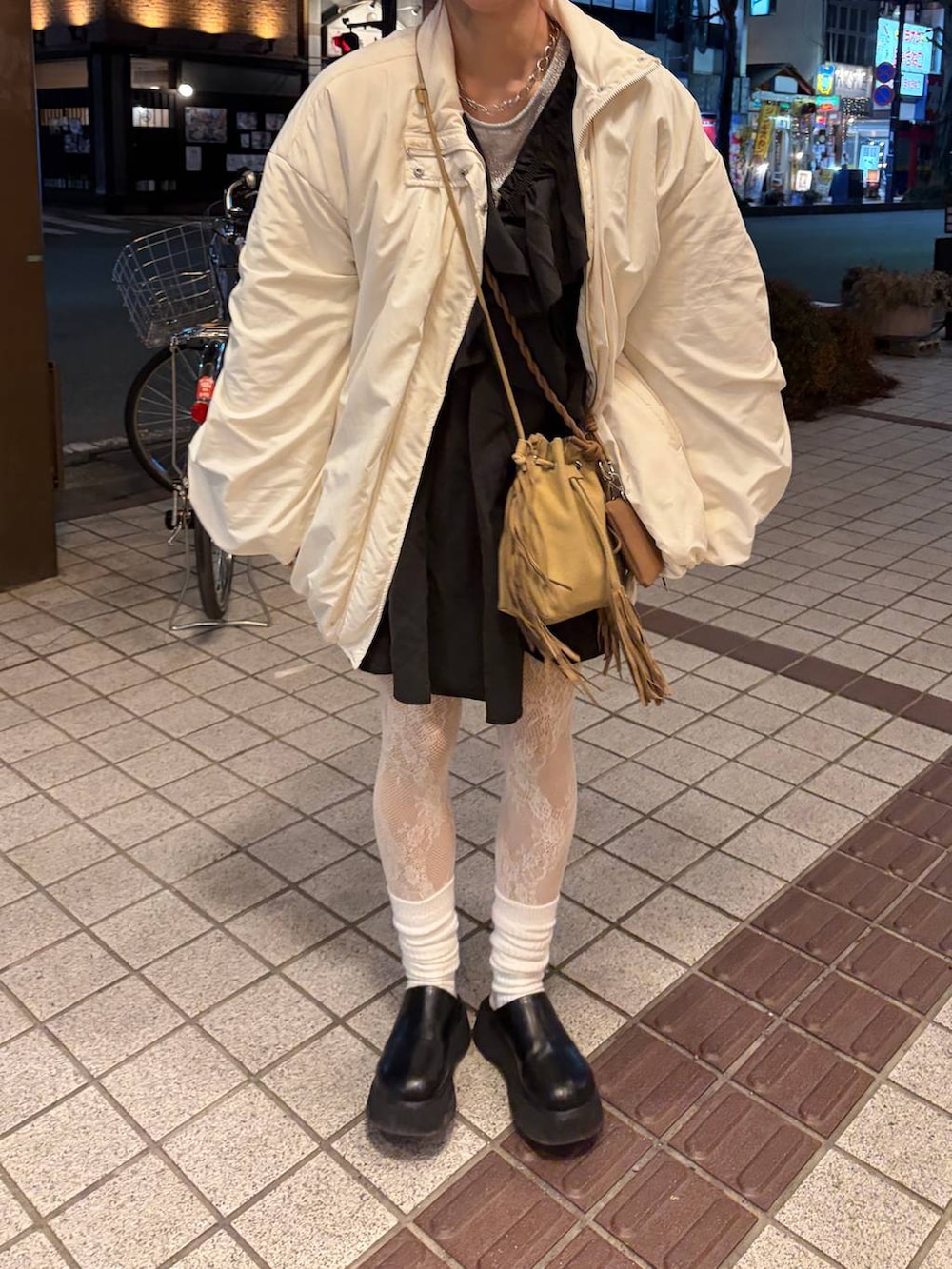 ブラック系のサンダル、ベージュ系のショルダーバッグ、ブラック系のワンピースを着用したレディースの冬コーディネートの2枚目の写真