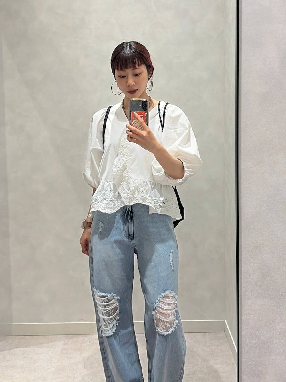 ゴールド系のタンクトップ、ブルー系のデニムパンツ、ホワイト系のシャツ/ブラウスを着用したレディースの春コーディネートの6枚目の写真
