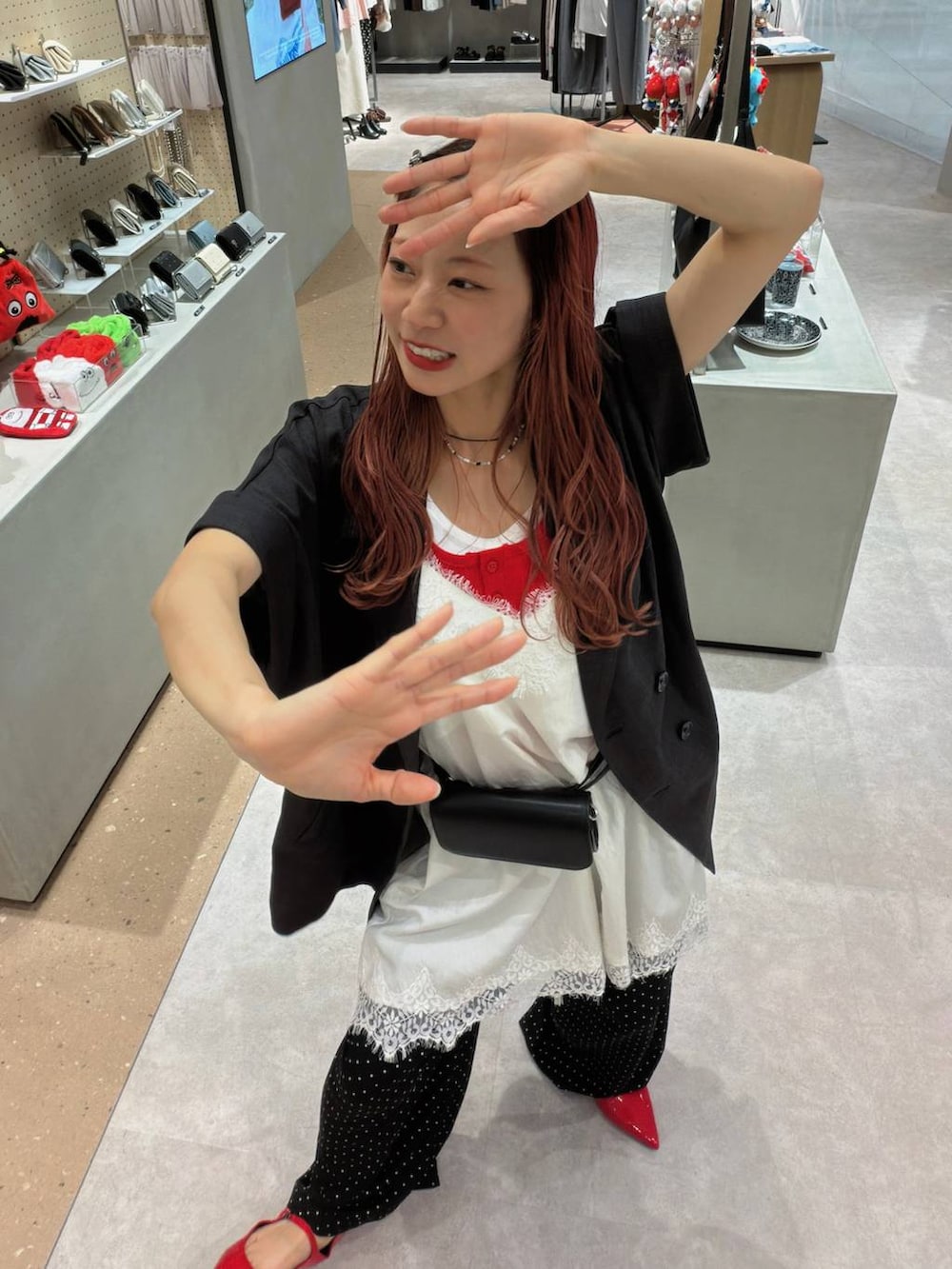 レッド系のパンプス、グレー系のテーラードジャケット、レッド系のタンクトップを着用したレディースの春コーディネートの7枚目の写真