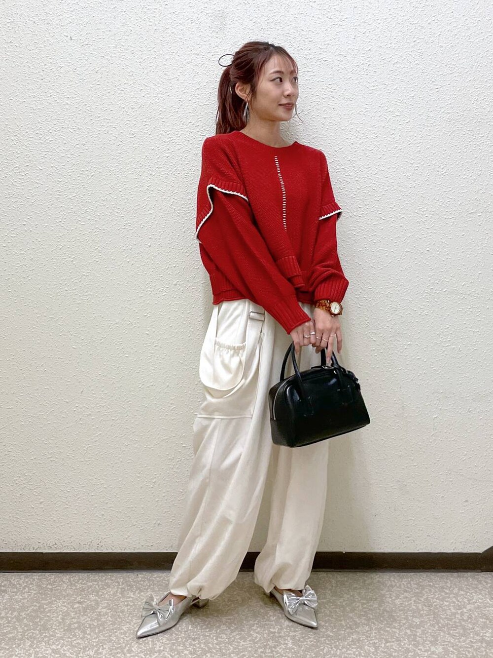 シルバー系のパンプス、ホワイト系のワンピース、ブラック系のボストンバッグを着用したレディースの秋コーディネートの3枚目の写真