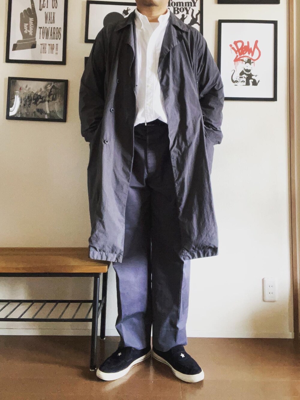 グレー系のトレンチコート、ブラック系のスニーカーを着用したメンズの秋コーディネートの2枚目の写真